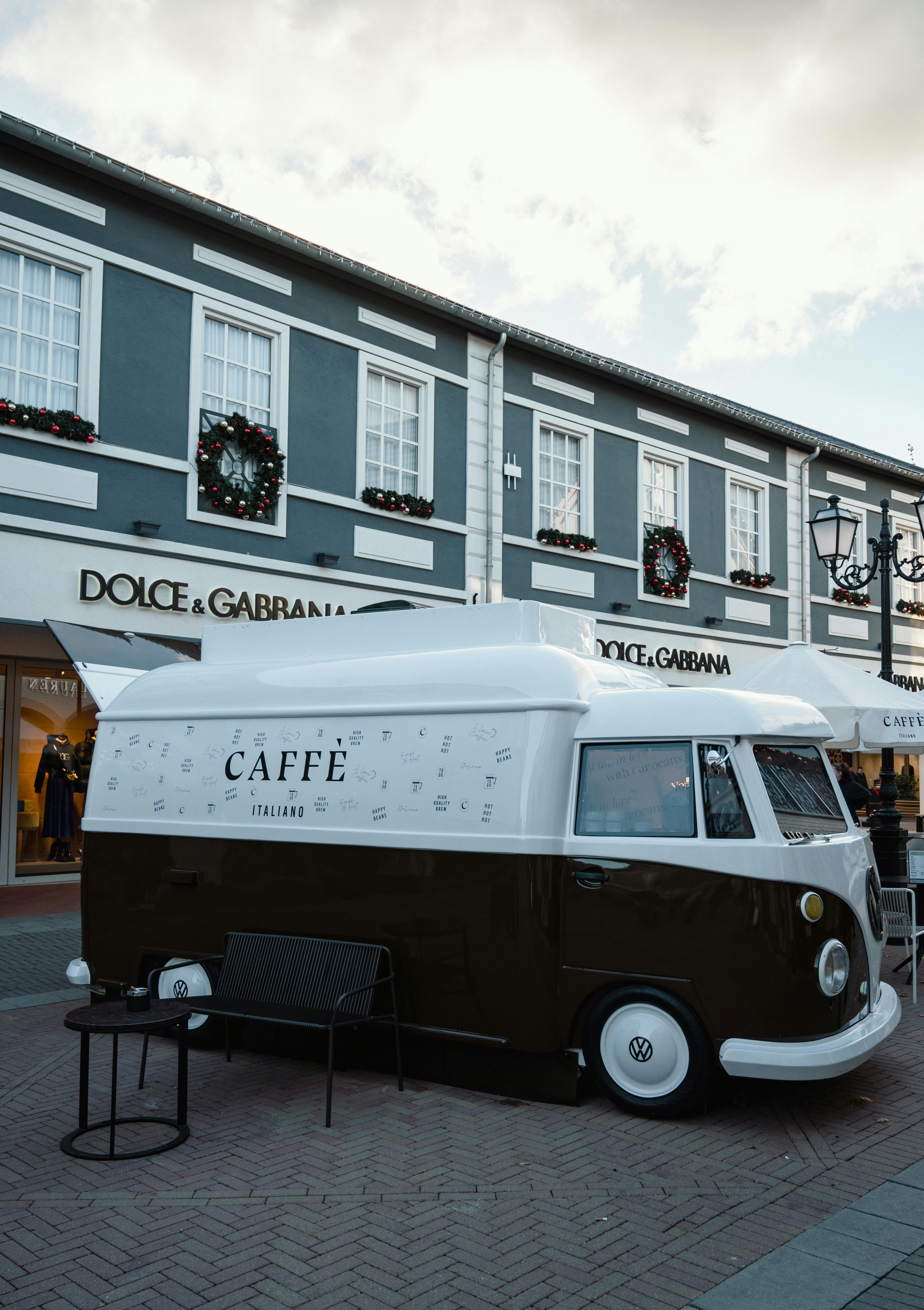 Un camion de café vintage garé devant les magasins.