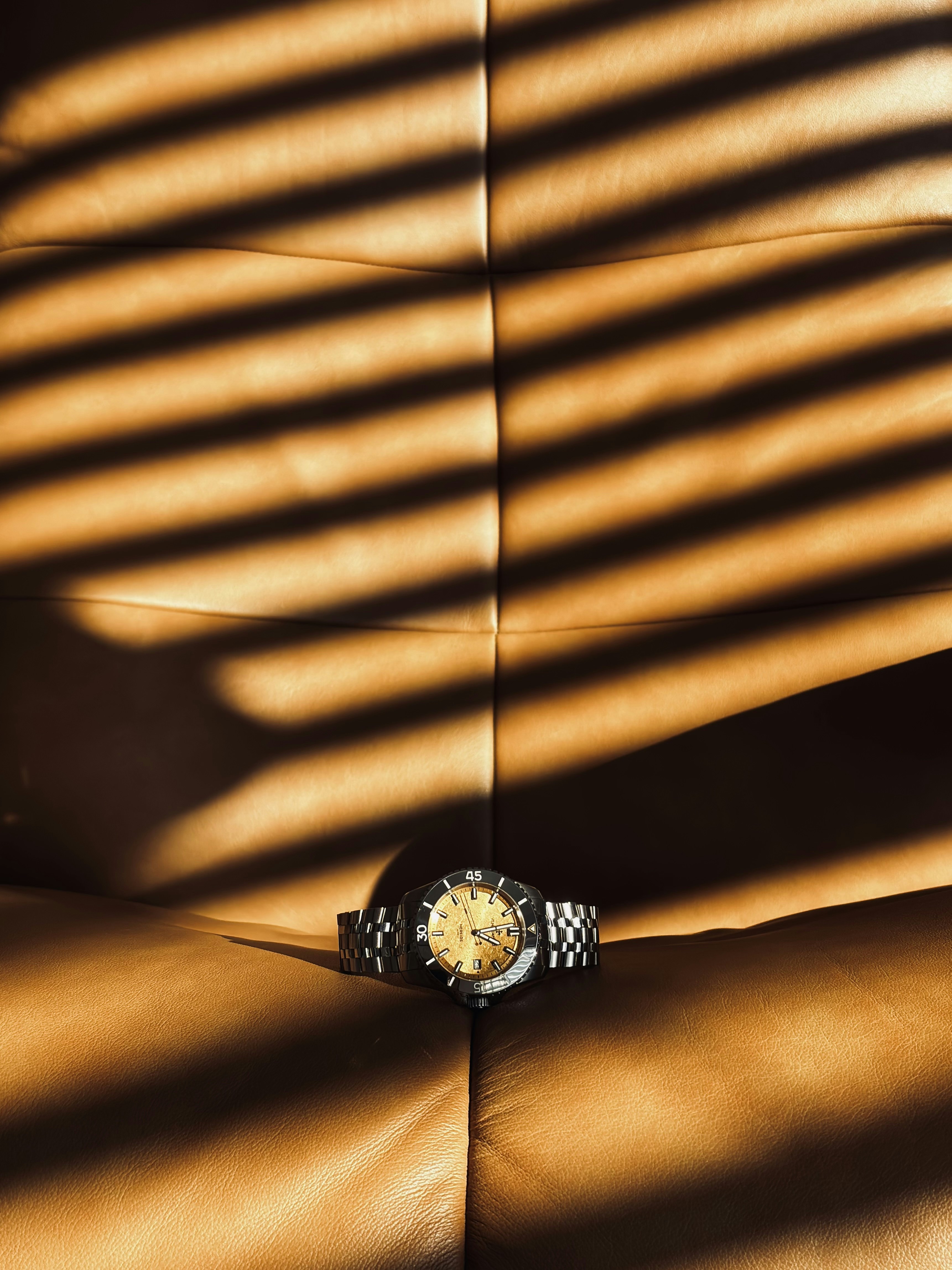 A wristwatch rests on a textured brown surface.