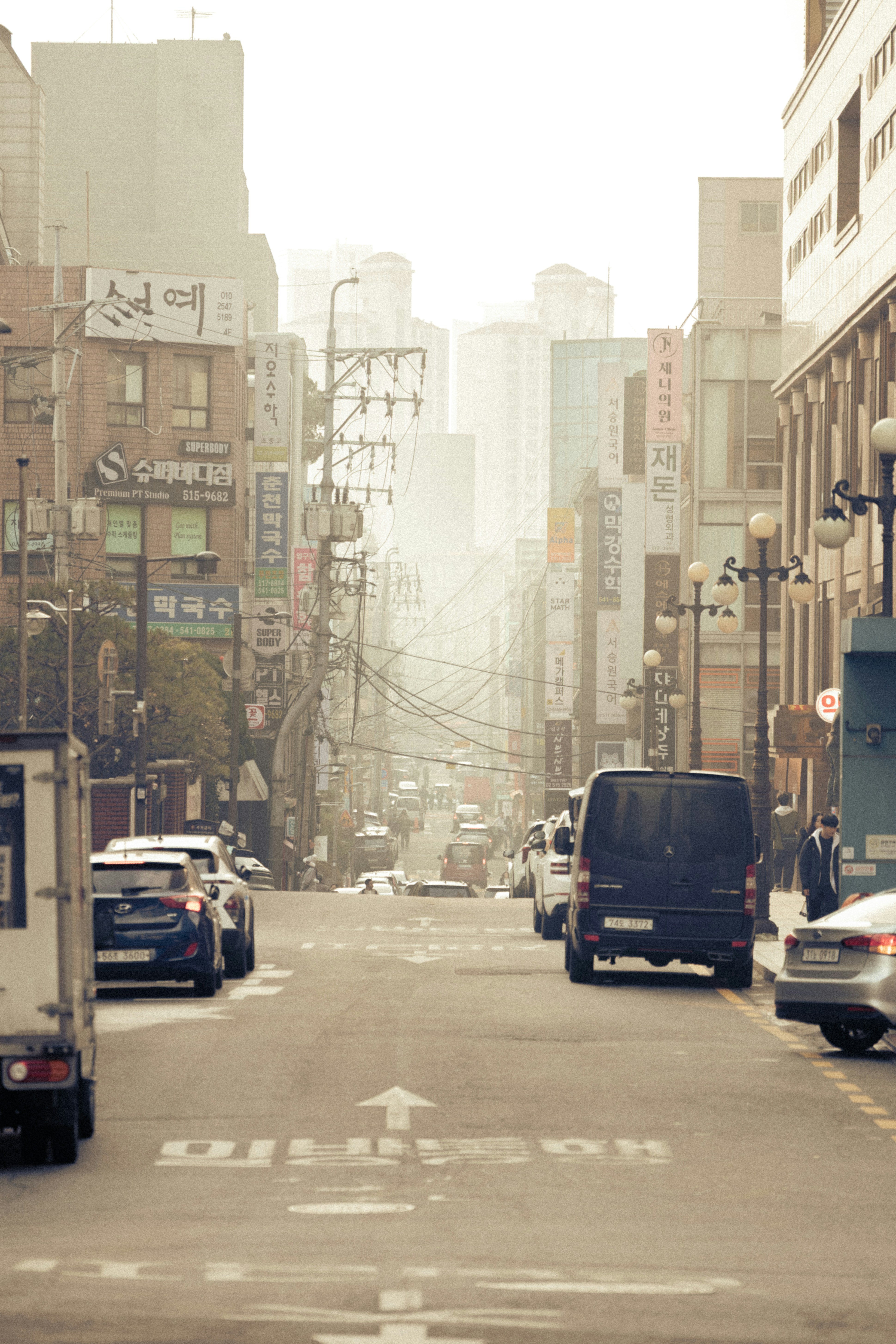 Vehicles on a hazy city street with buildings