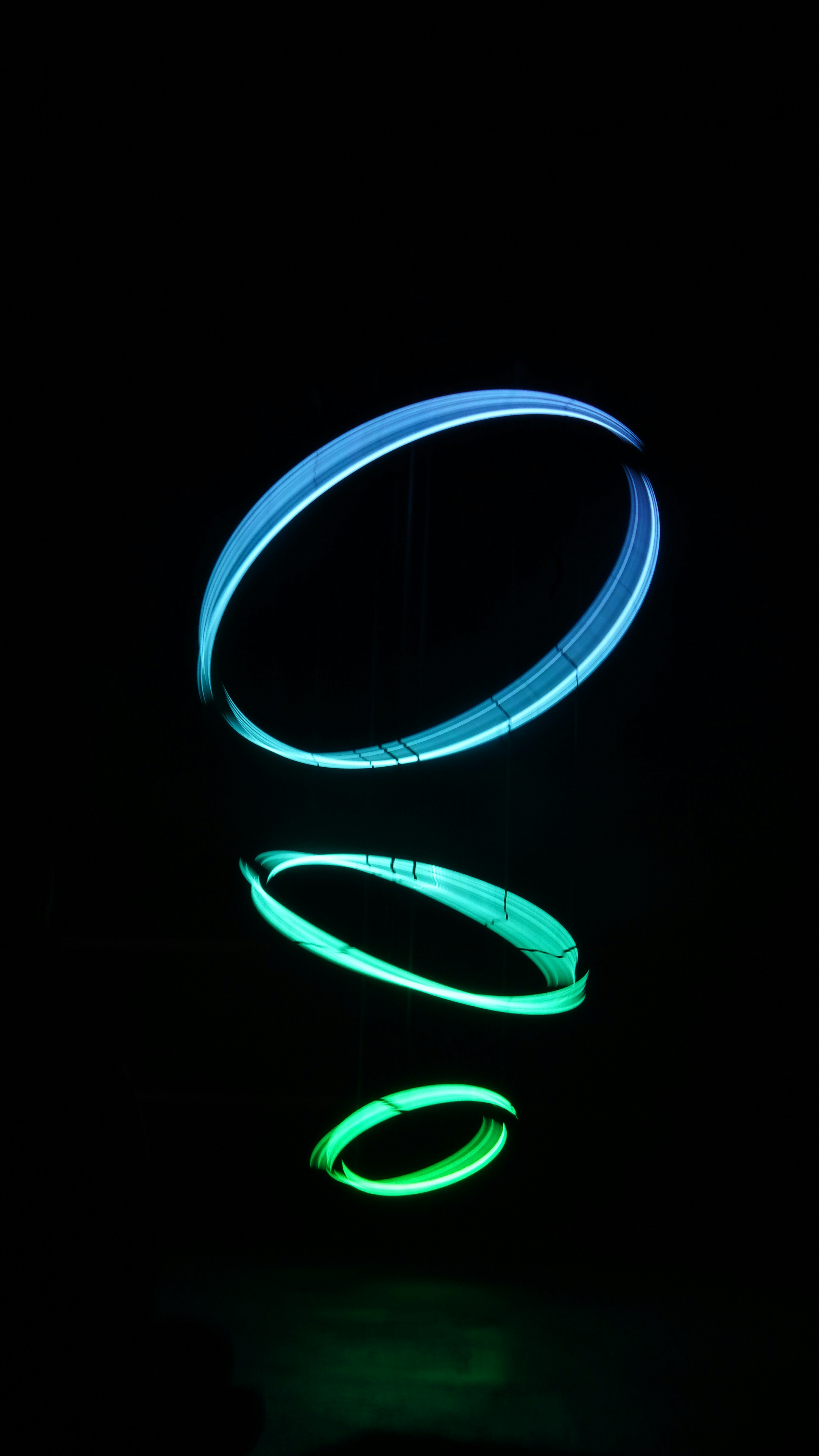 Three glowing rings suspended in darkness