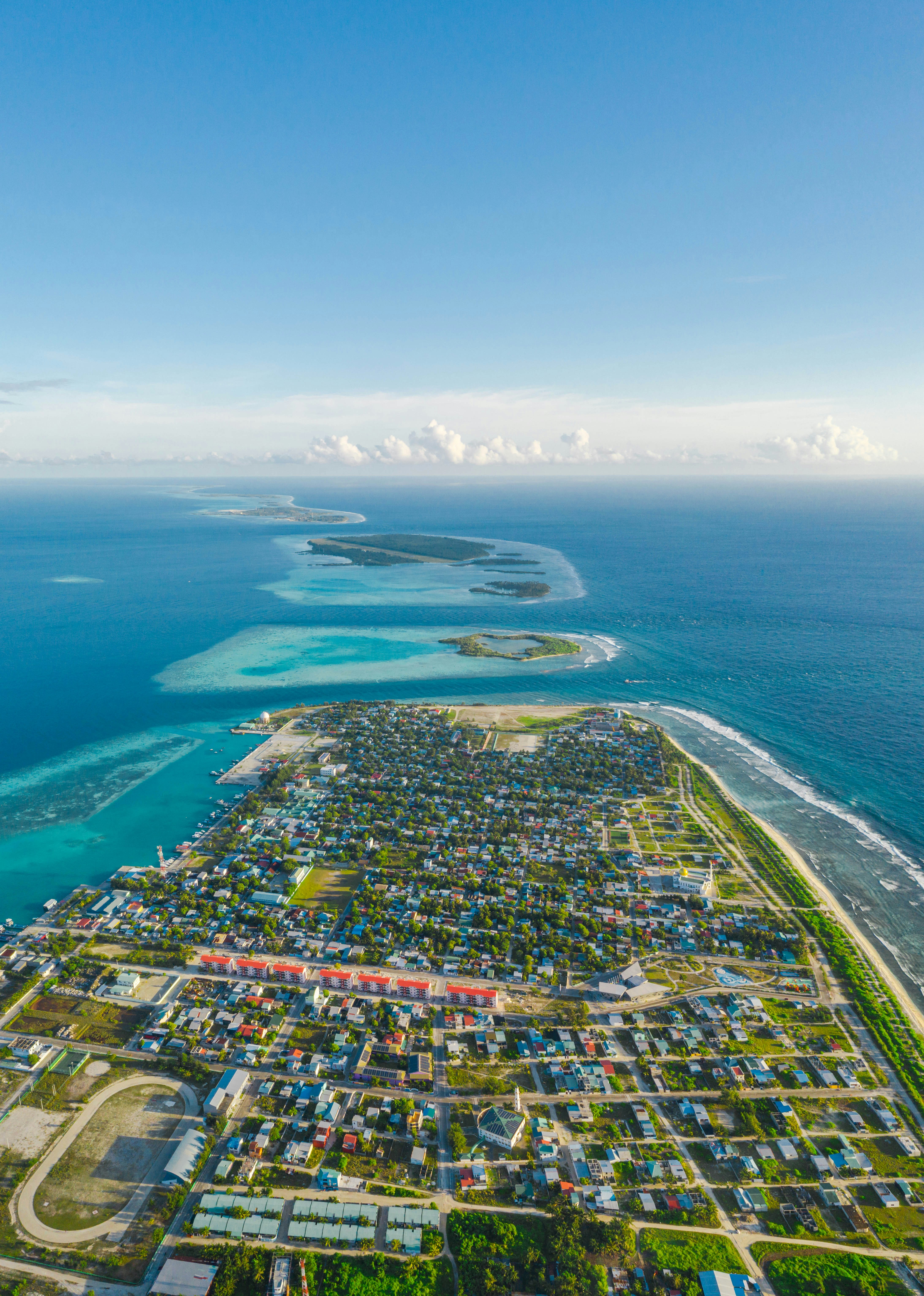 Aerial view of a tropical island town and surrounding ocean.