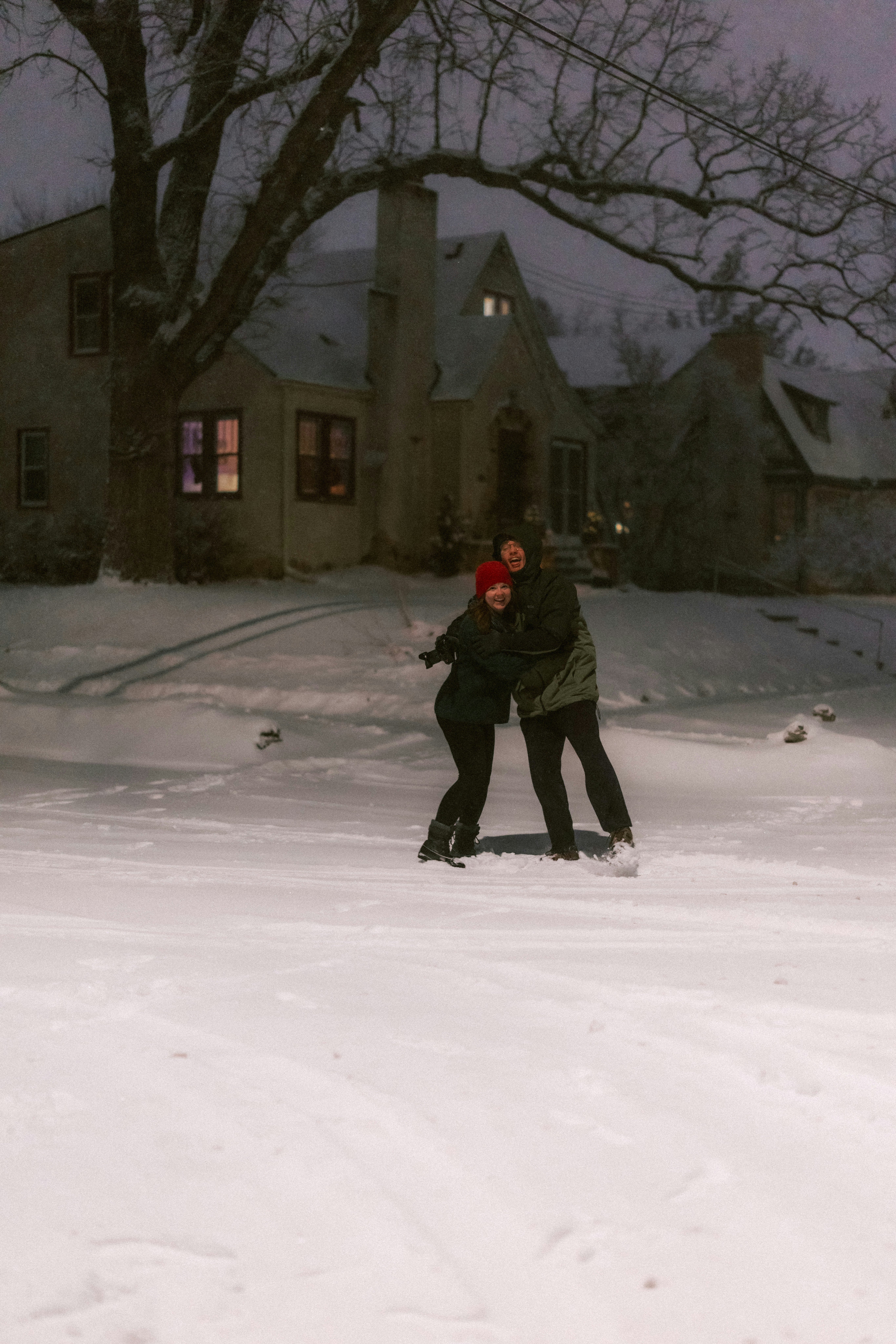 Couple hugging in the snow at night