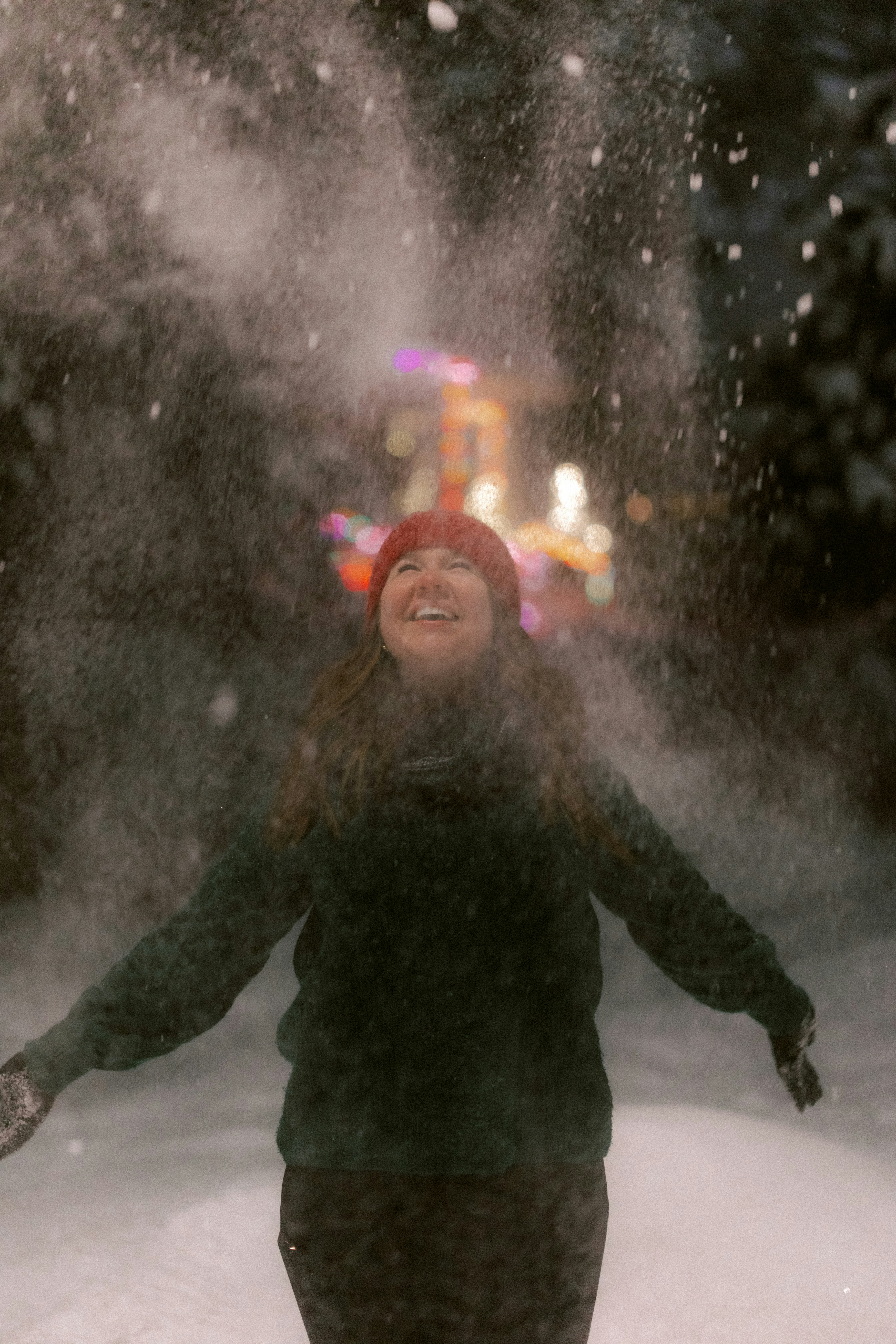 Woman laughing as snow falls around her