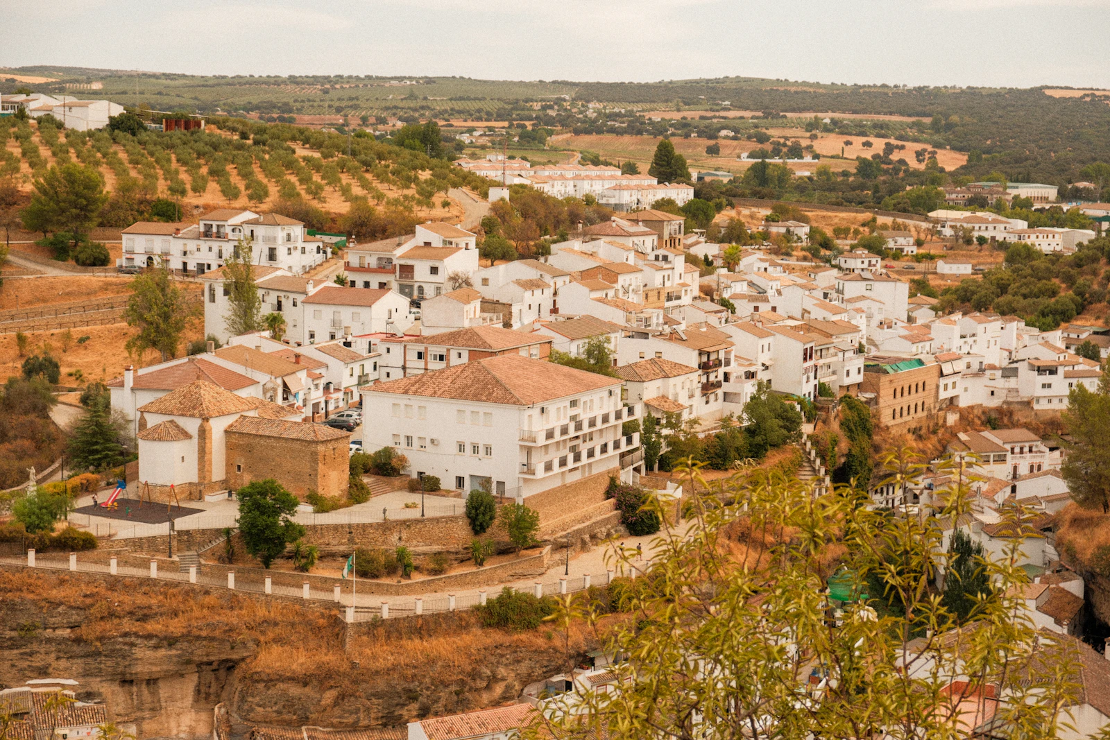 Pueblo blanco de Andalucía en una ladera entre olivares