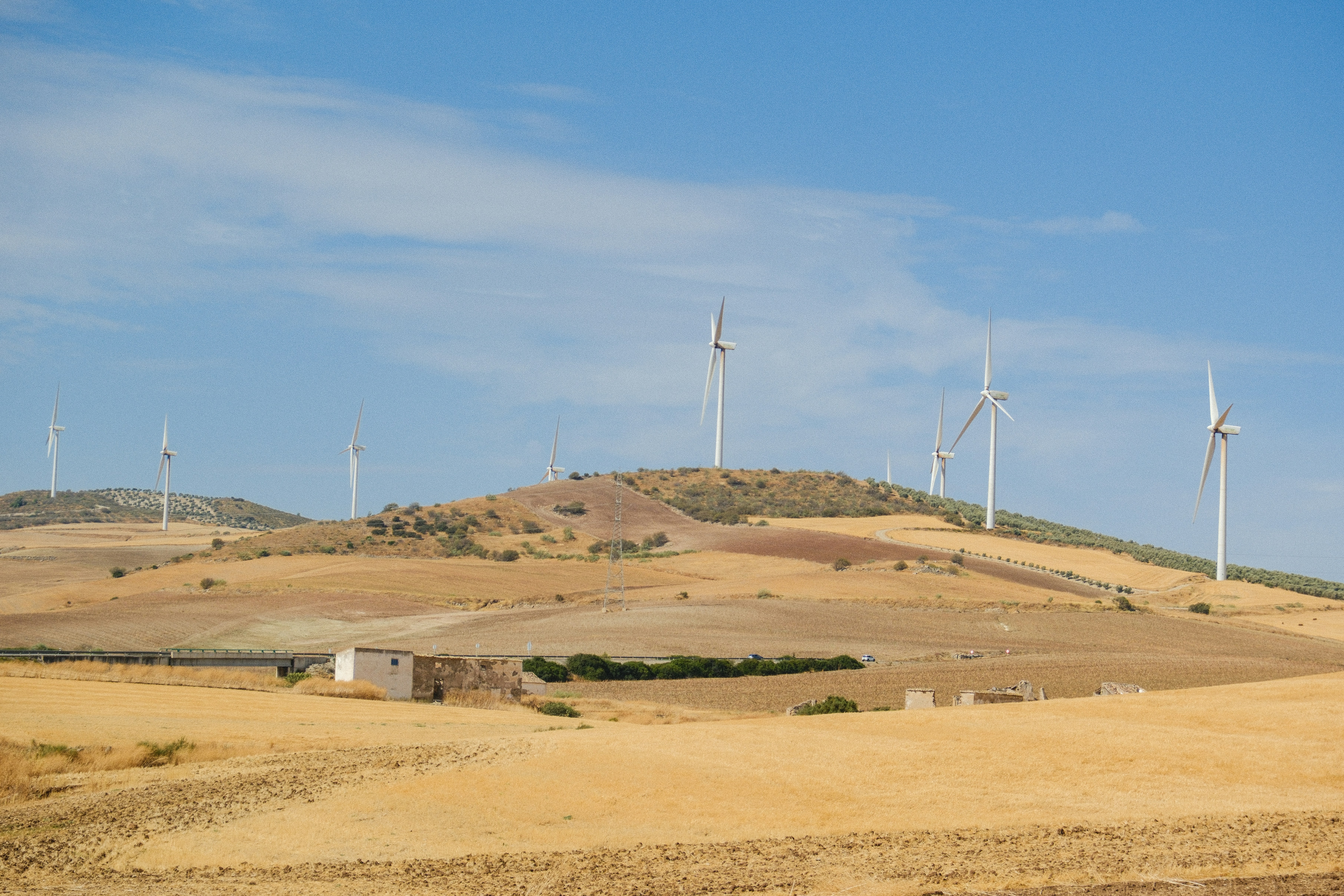 Wind turbines on a dry, rolling landscape.