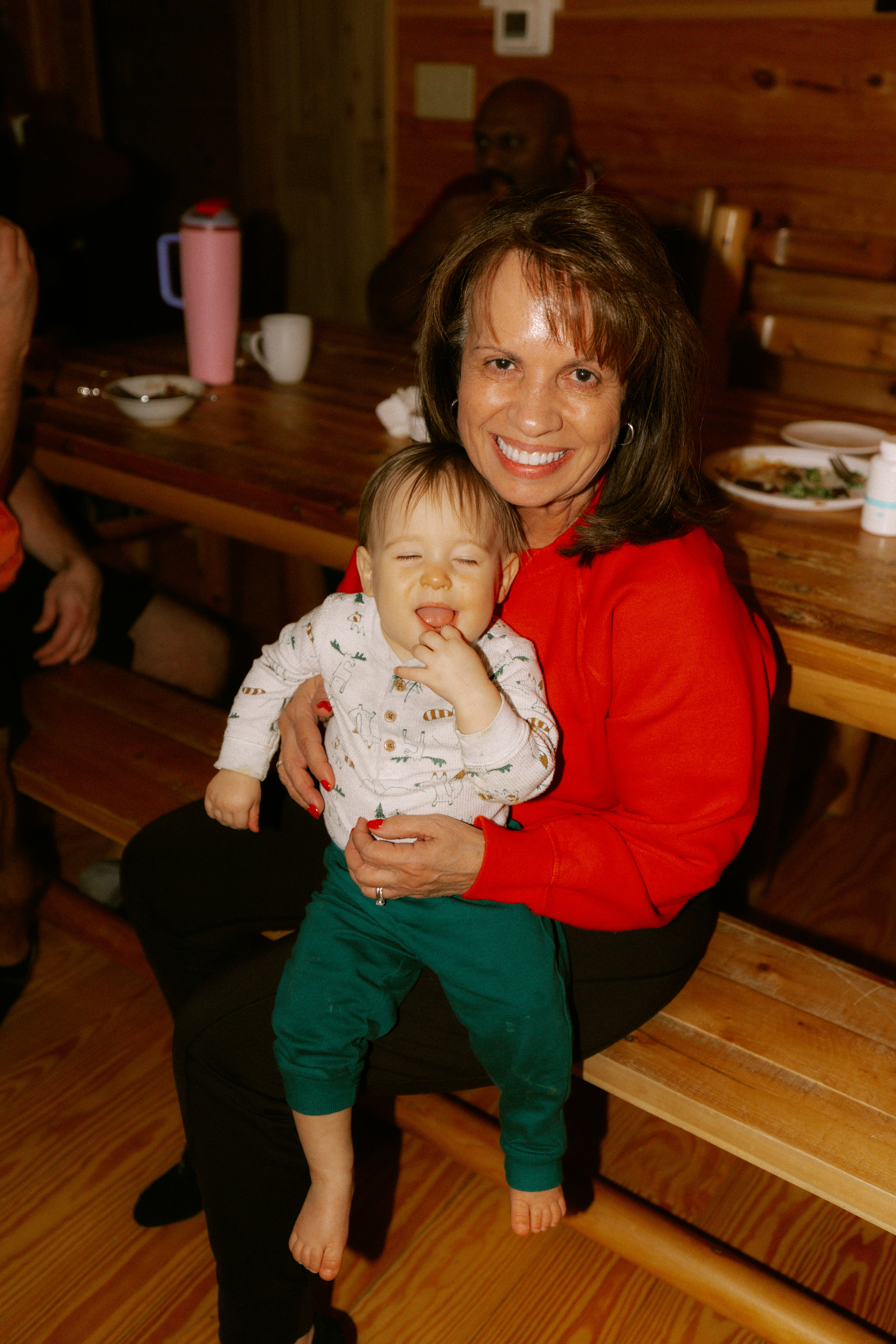 Woman holding a baby at a wooden table