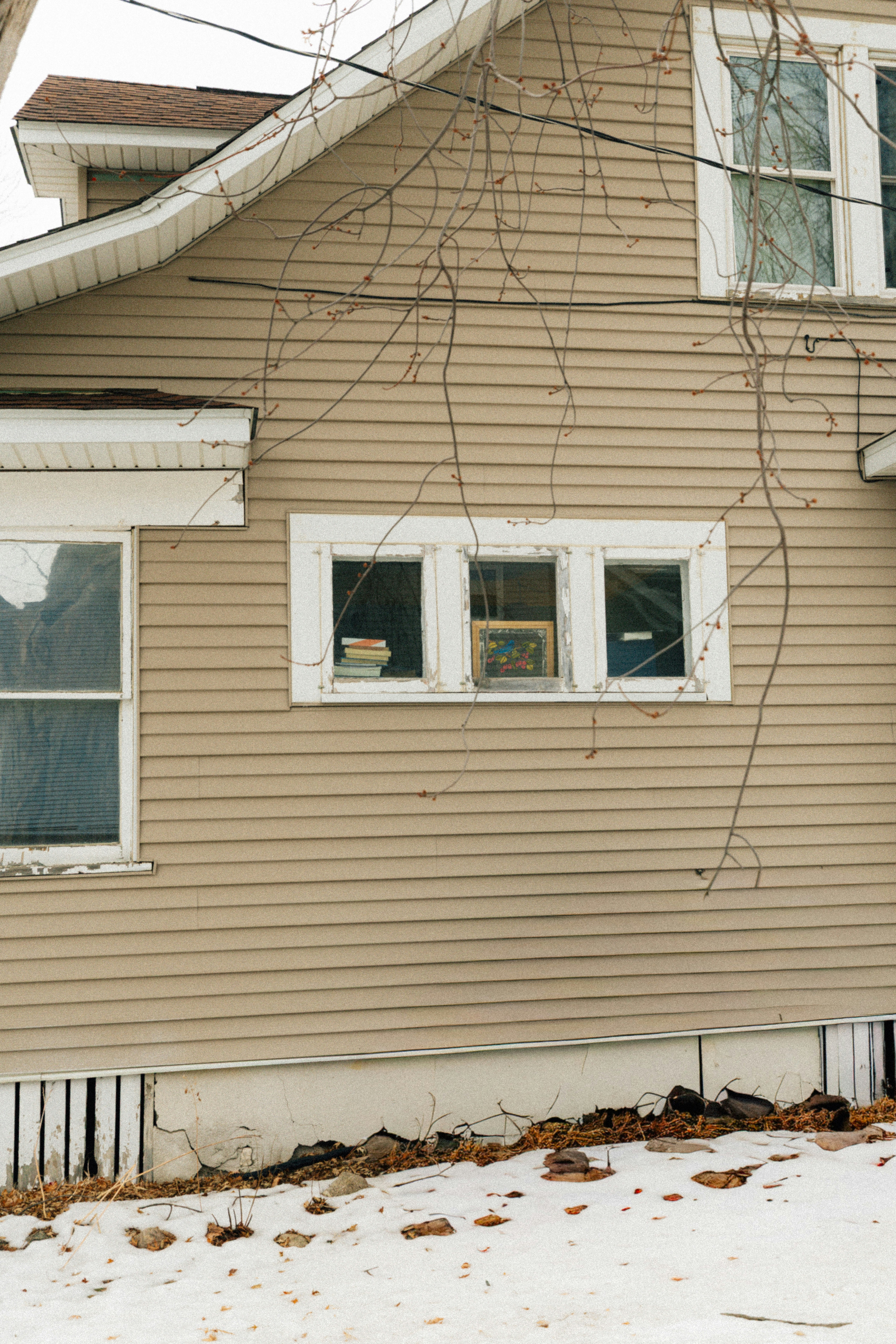 Tan house with white trim and three windows