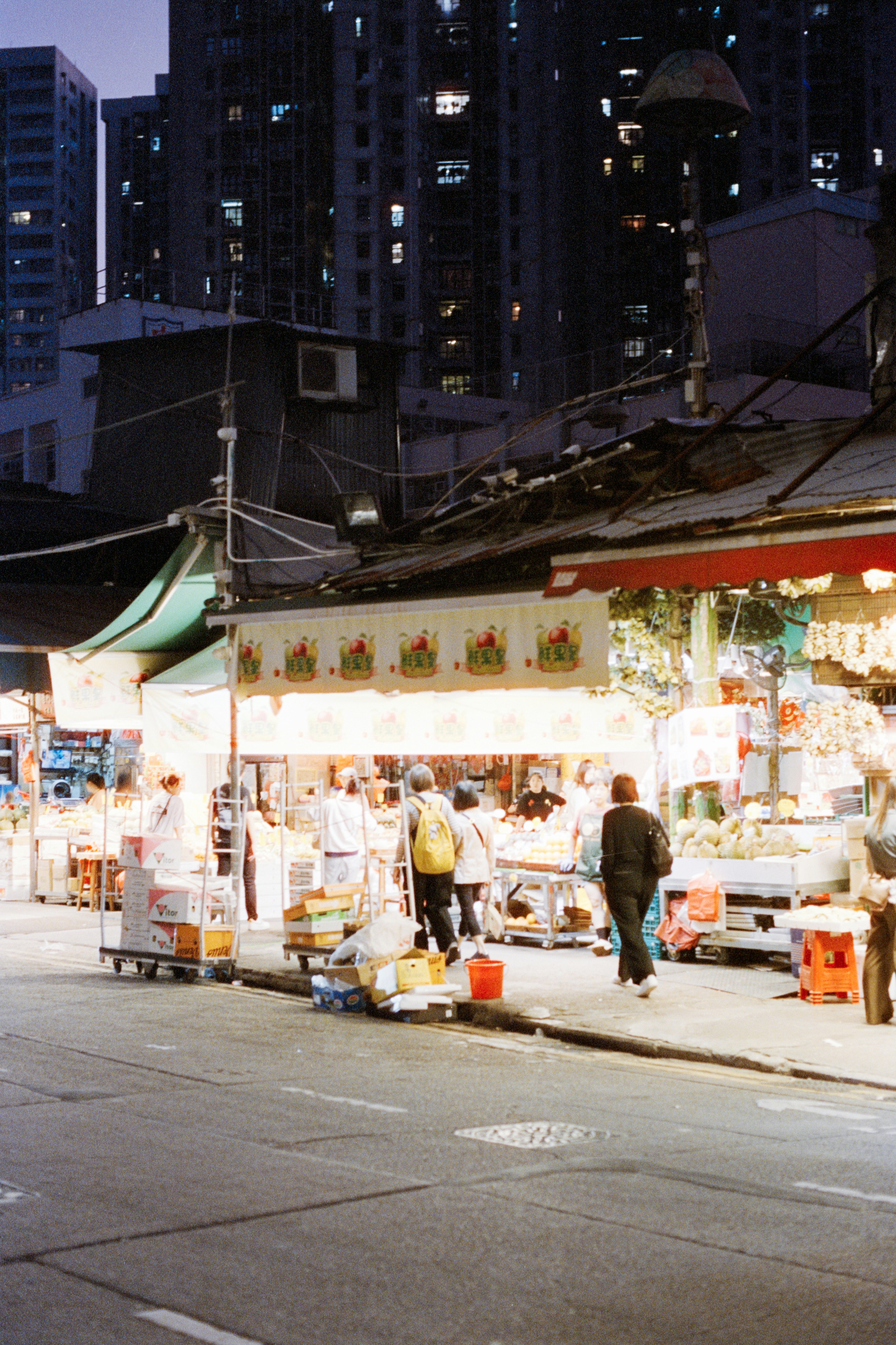 Street market stalls at night with buildings in background