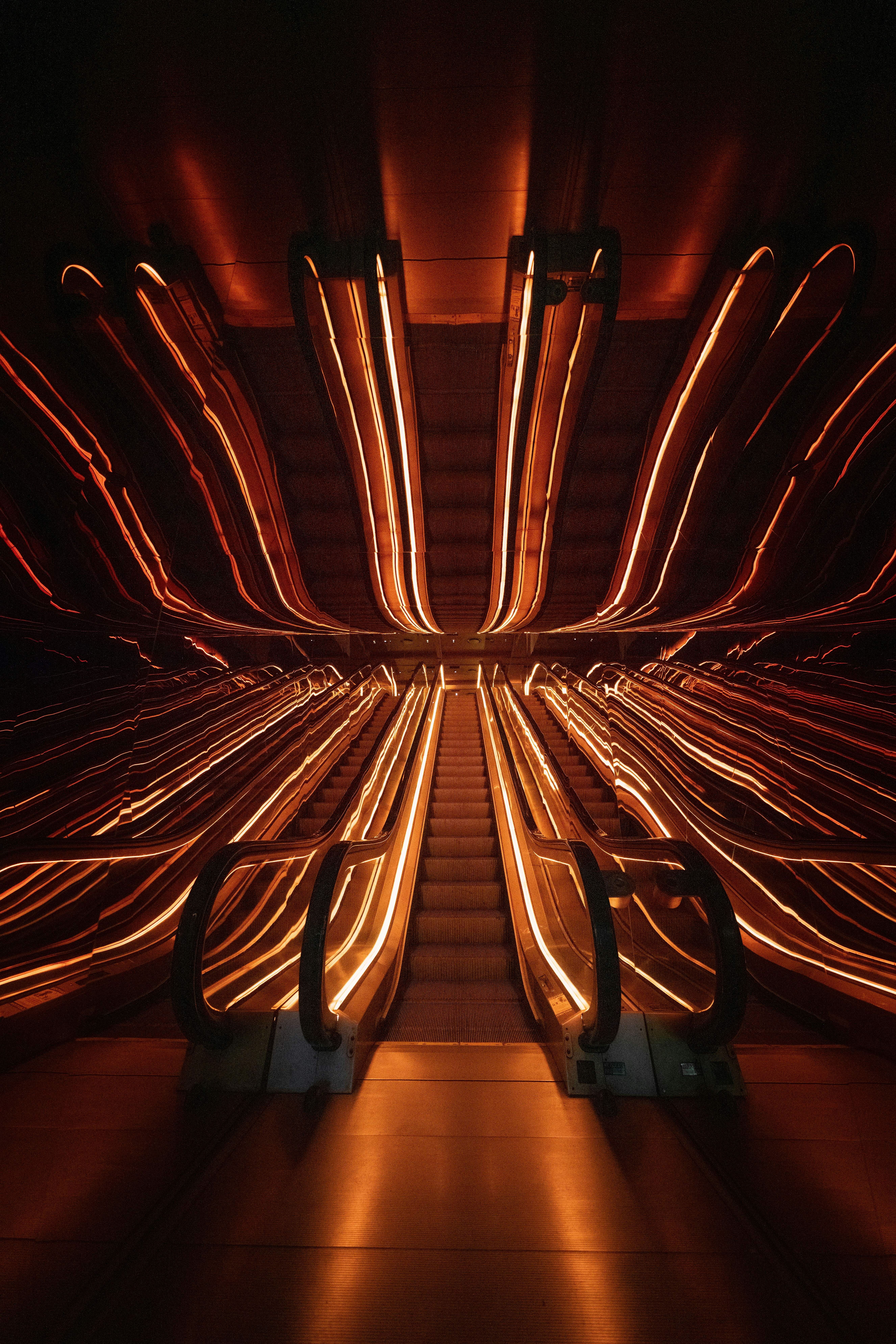 Escalators with glowing orange light trails