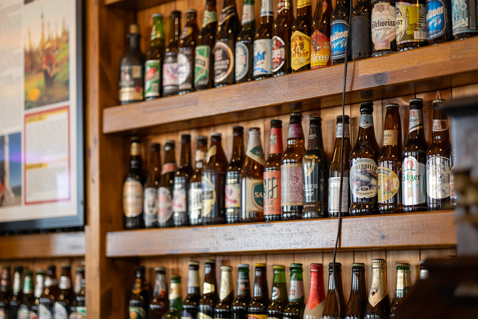 Garrafas de cerveja expostas em prateleiras de madeira