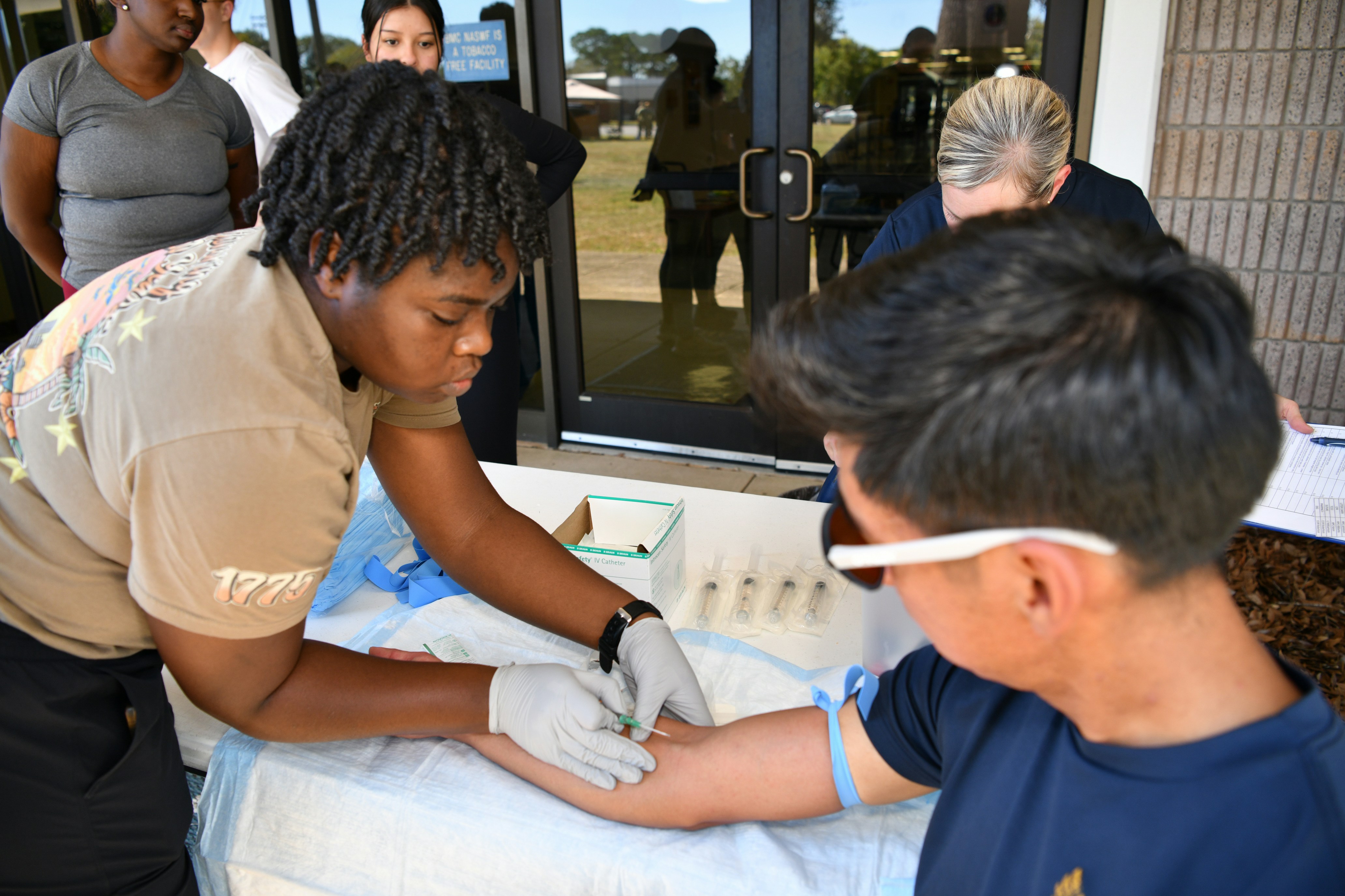 Medical professional draws blood from a patient's arm.