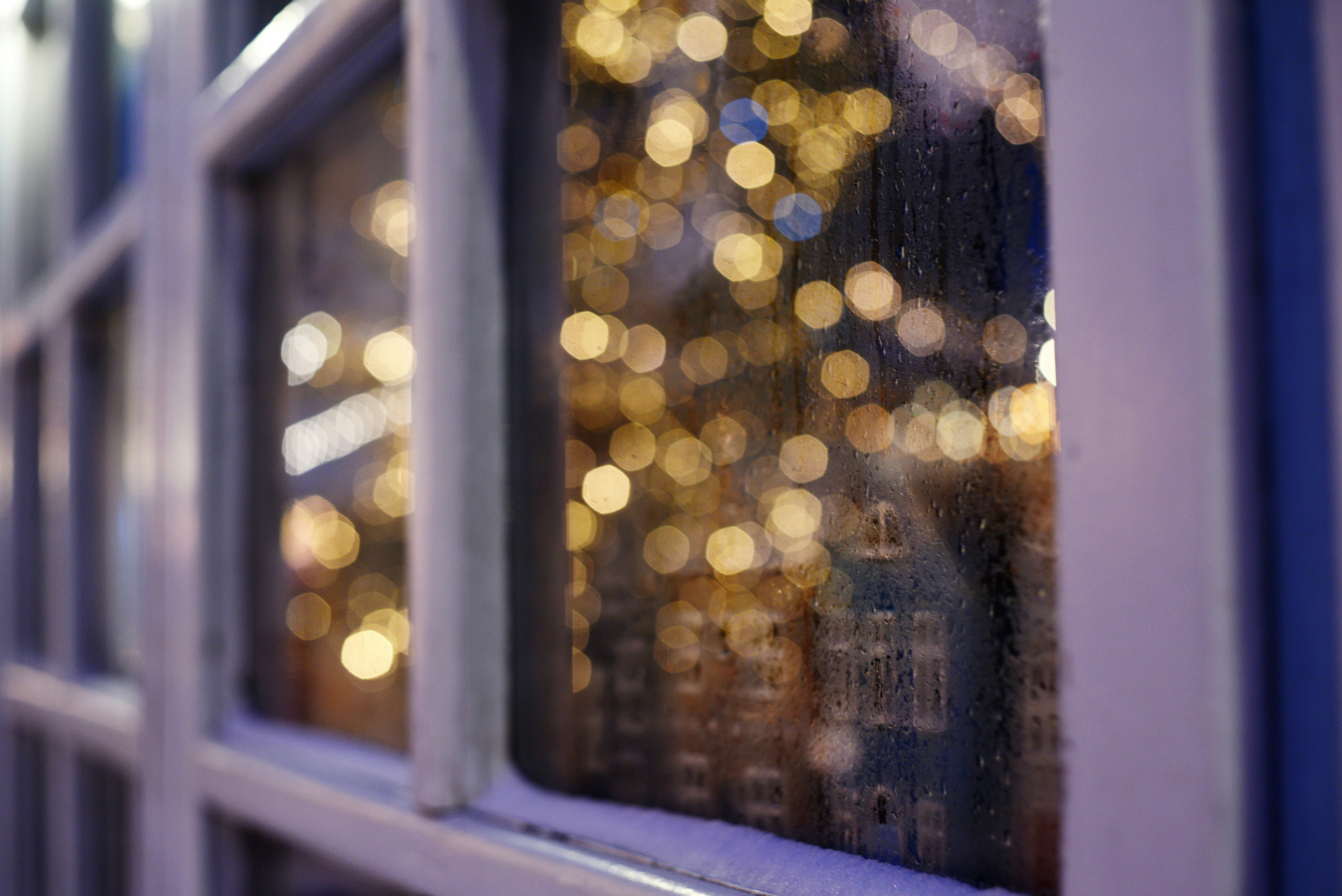 Bokeh lights reflected on a window pane.