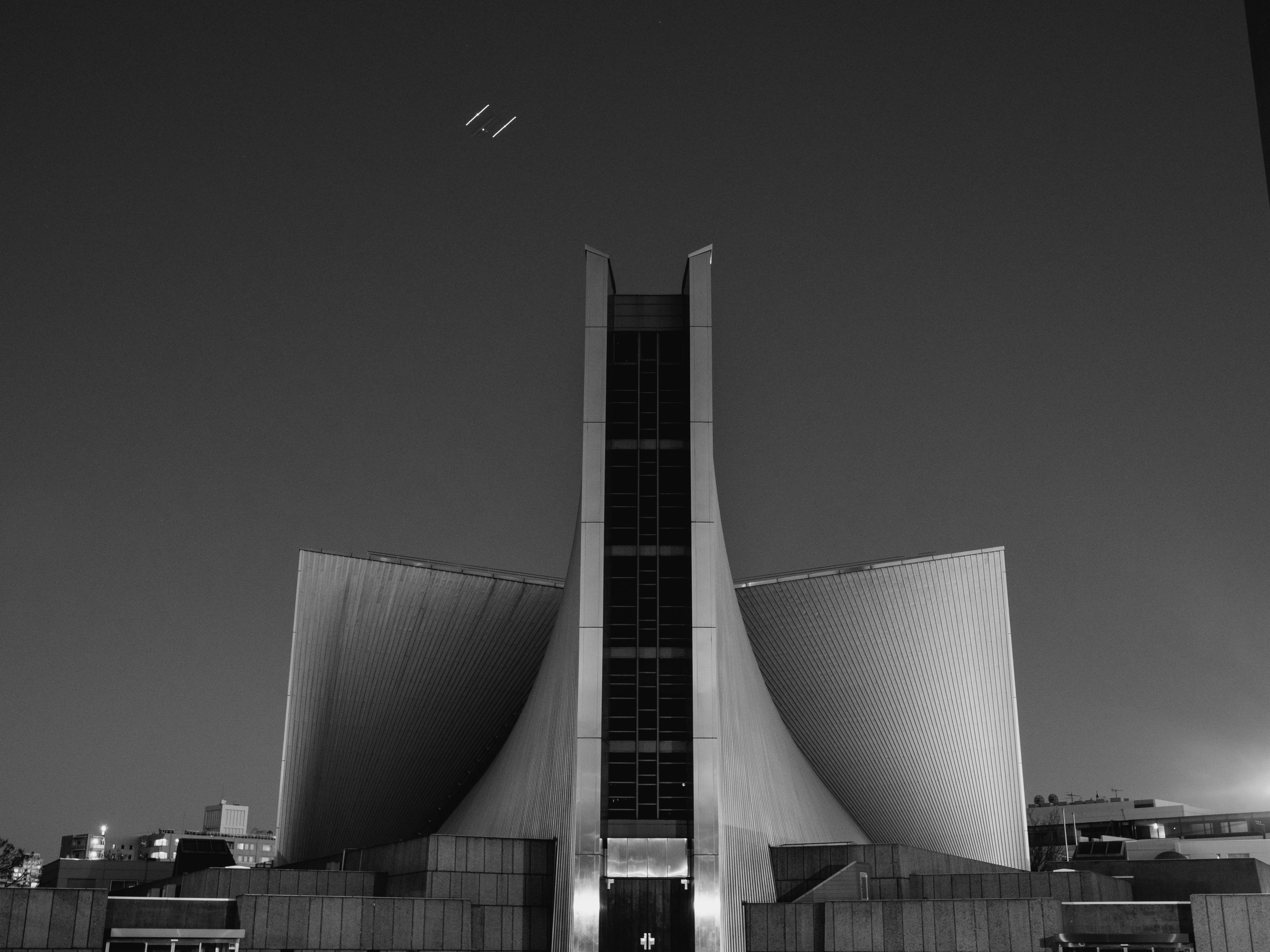 Catedral moderna de hormigón contra un cielo nocturno.