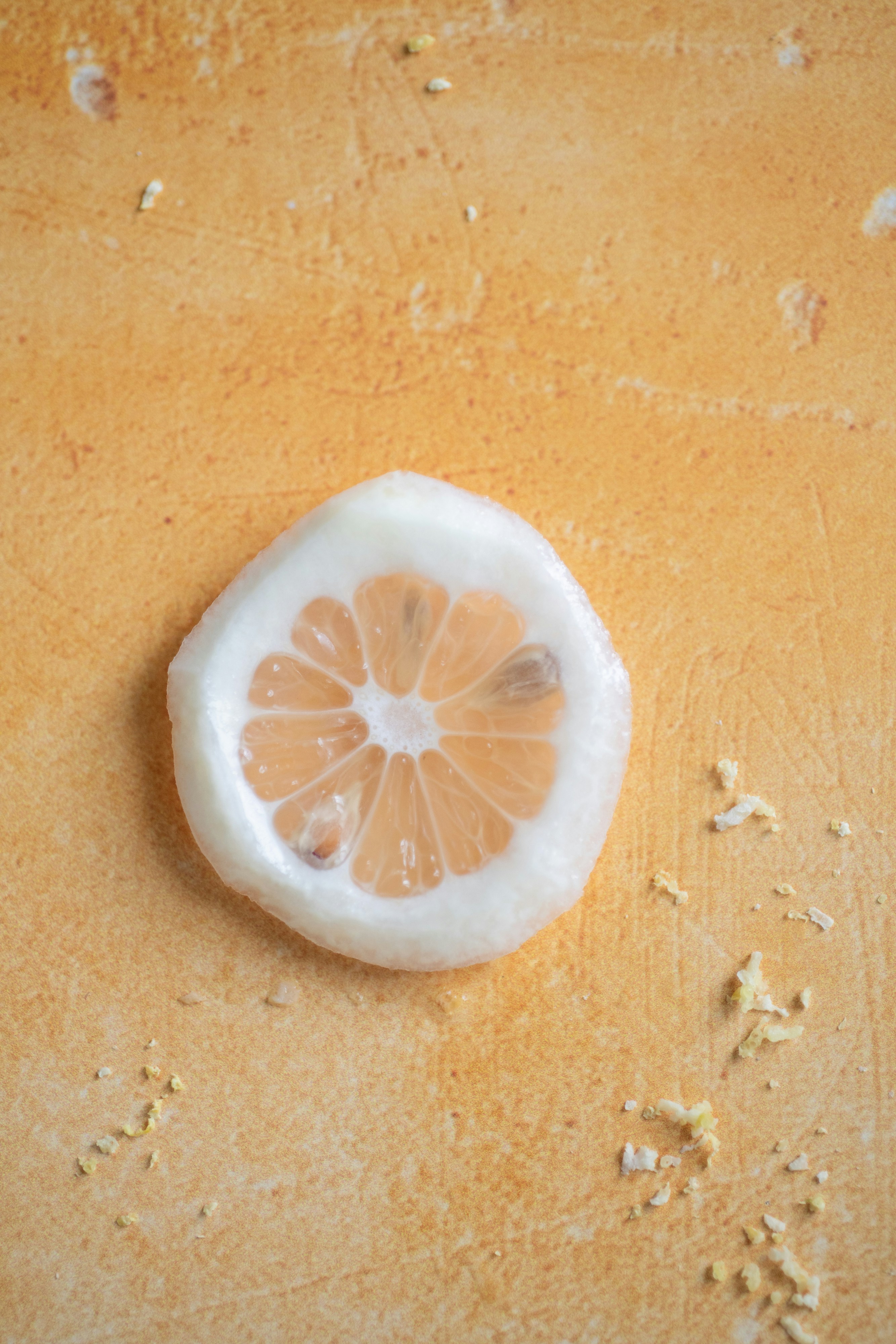 A single slice of lemon on a textured surface