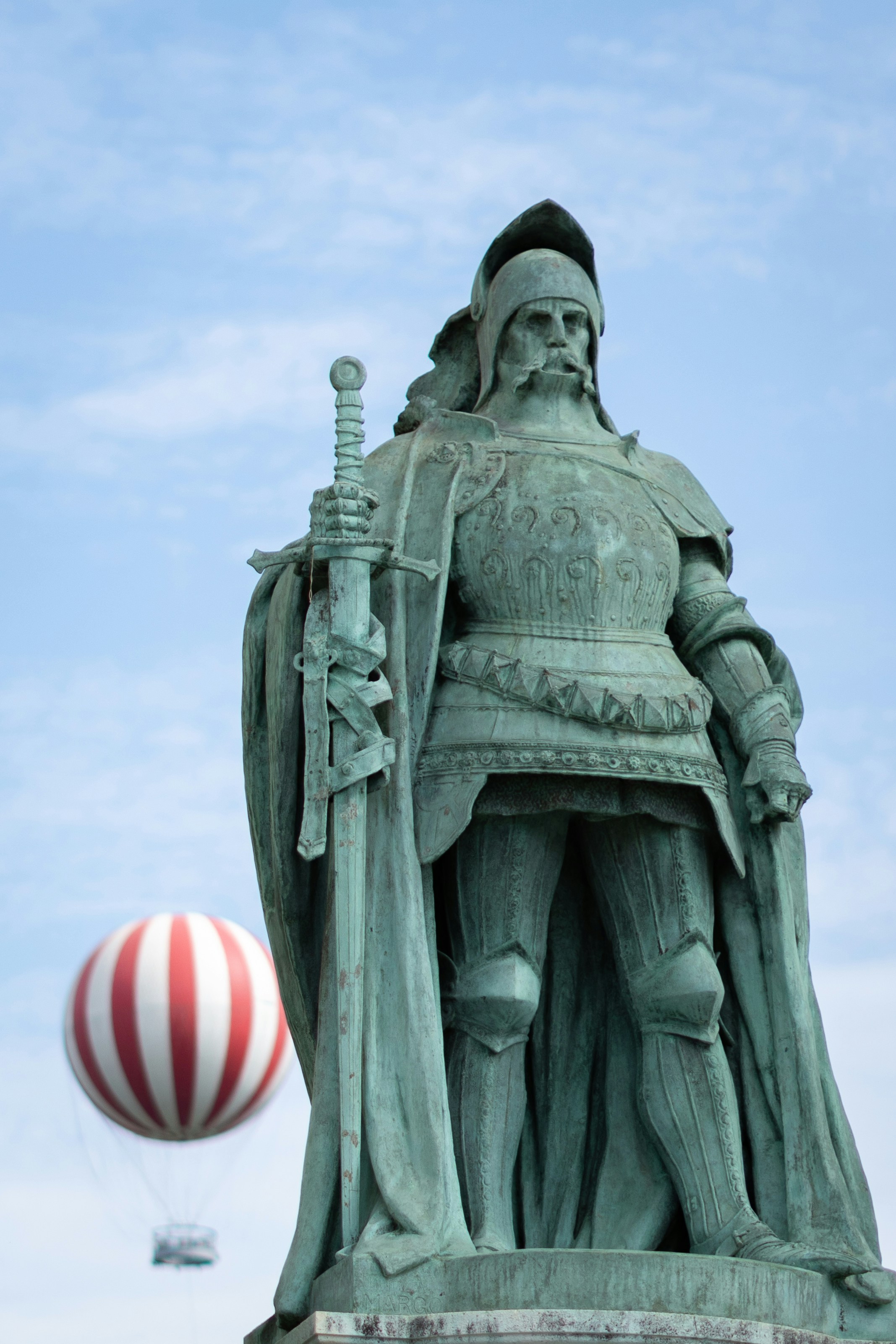 Bronze statue of a knight holding a sword with balloon.