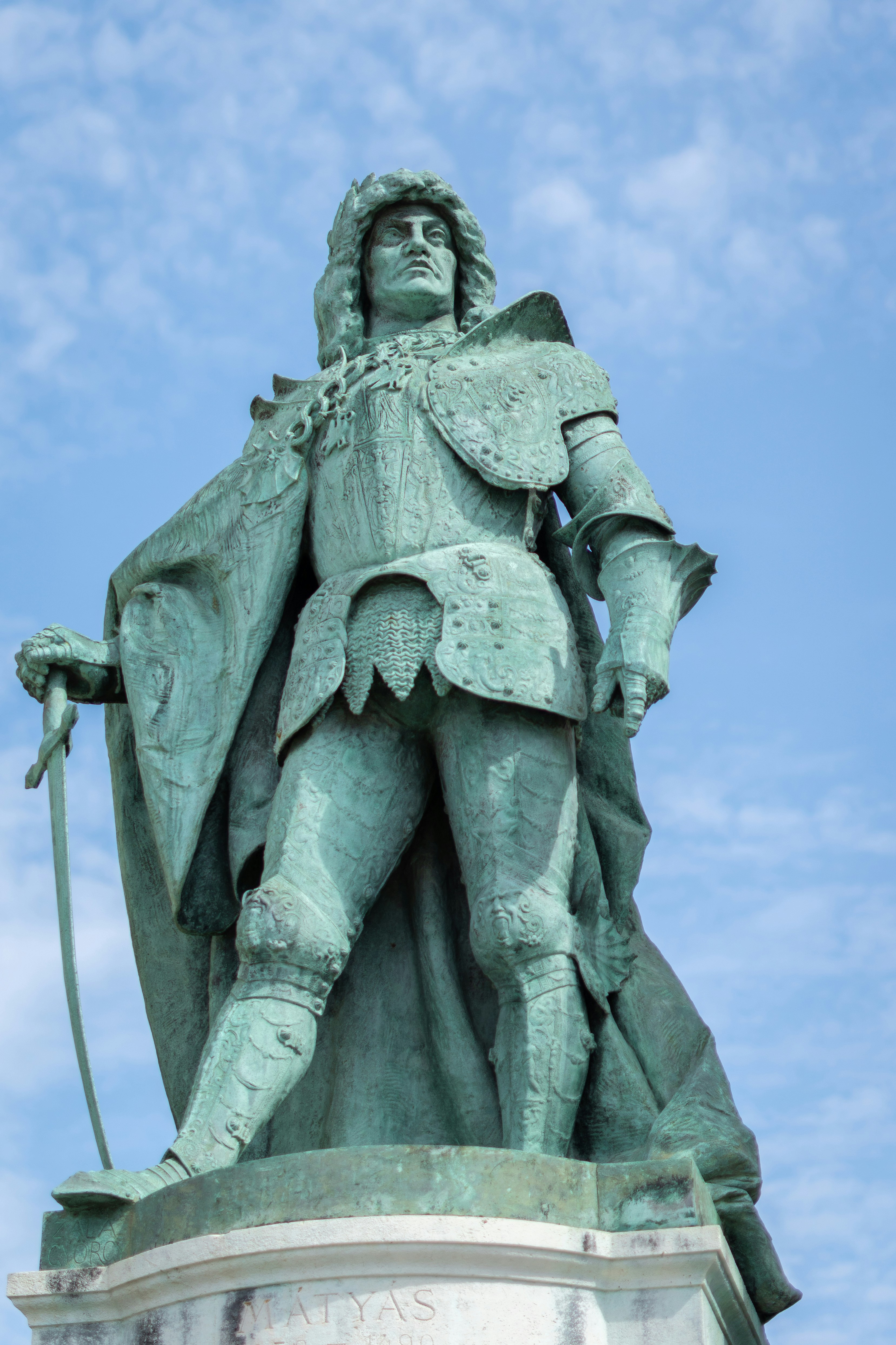 Bronze statue of a man in armor with sword.