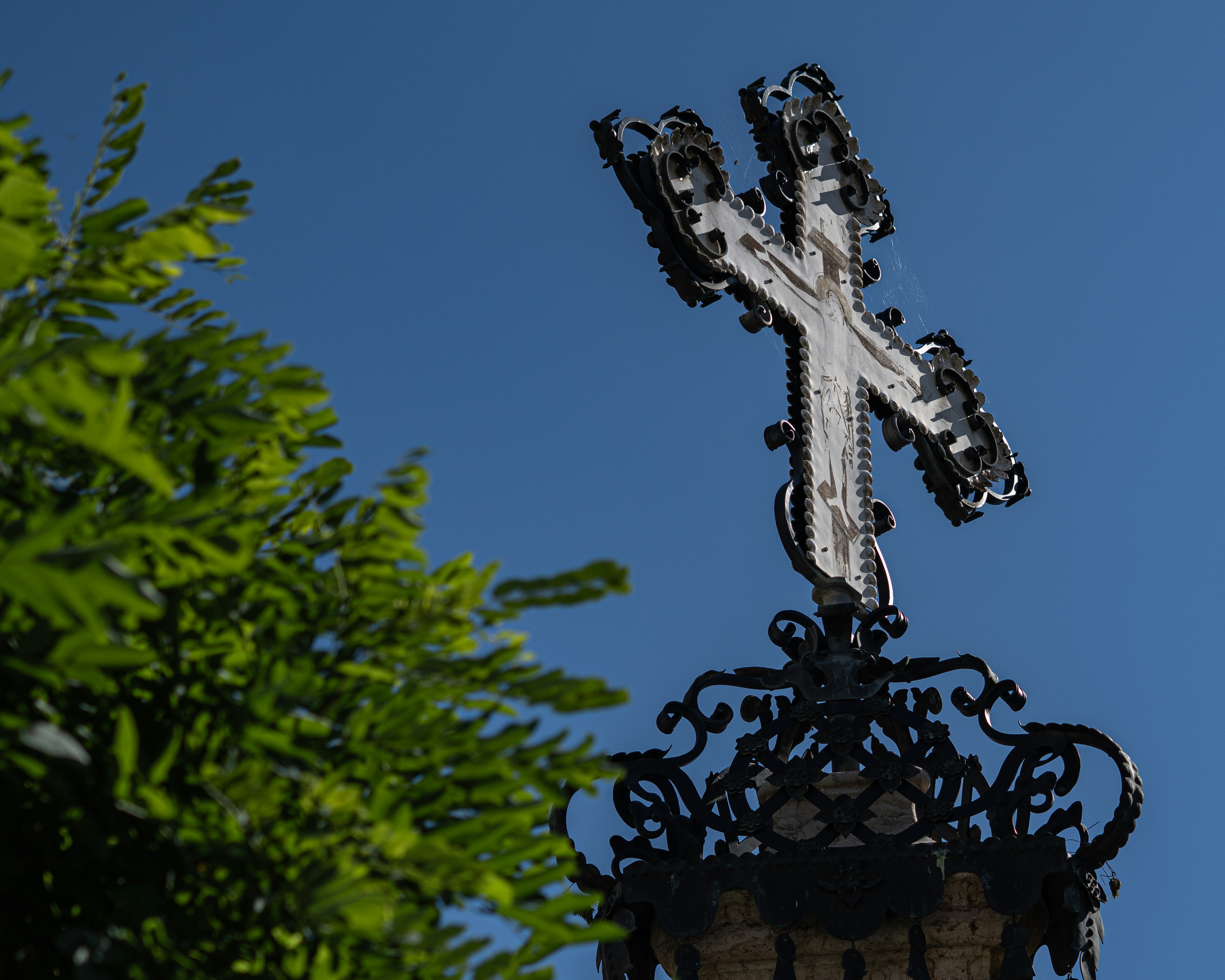 Ornate cross against a clear blue sky.