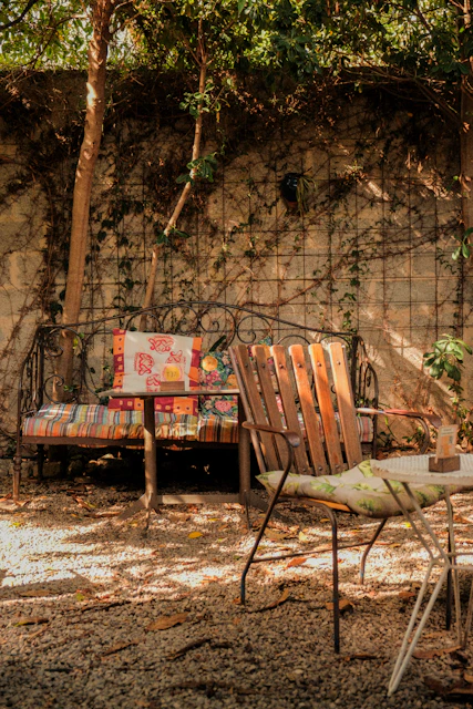 Outdoor seating area with a bench and chairs.