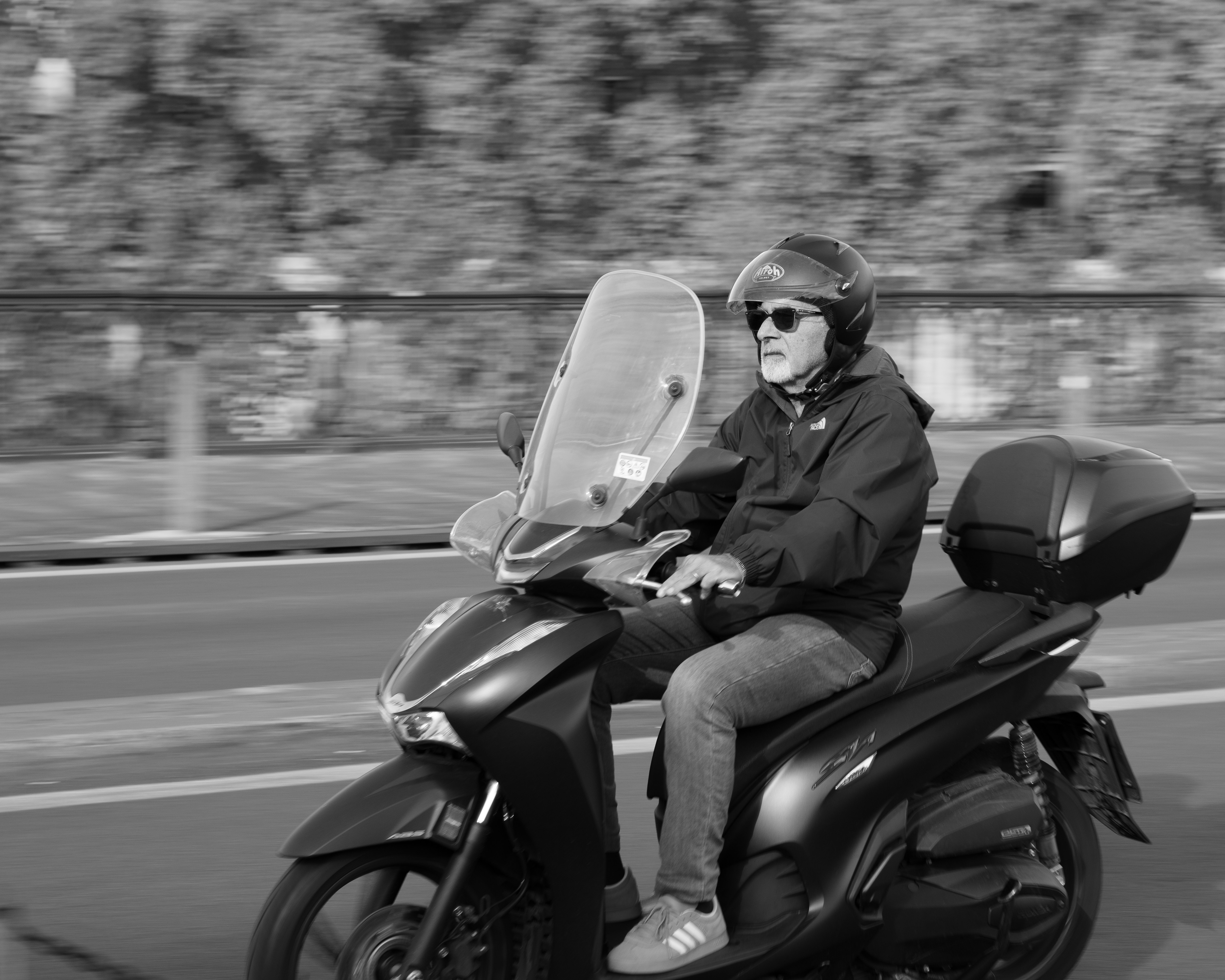 Man riding a scooter on a road