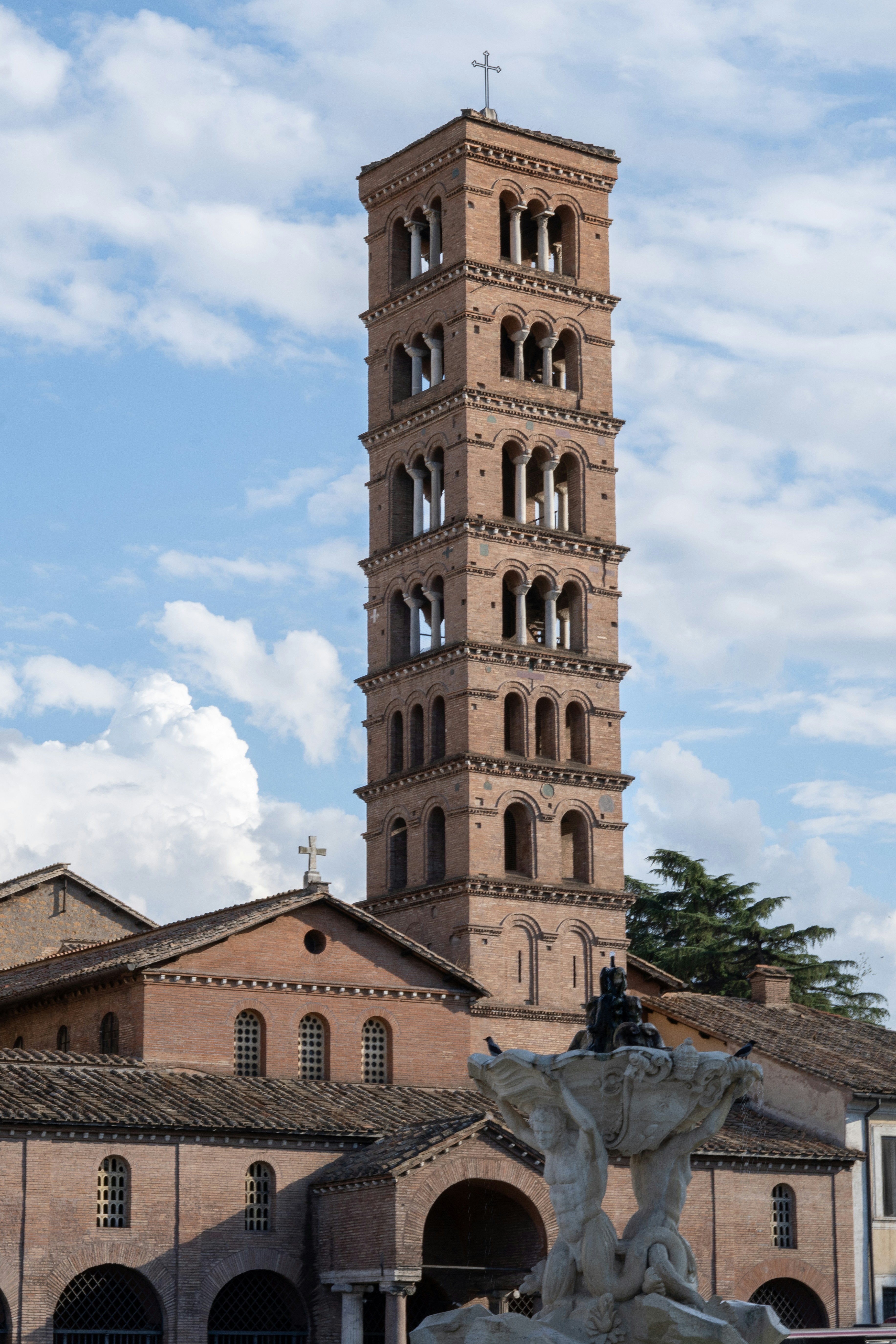 Tall brick bell tower with arched windows above church