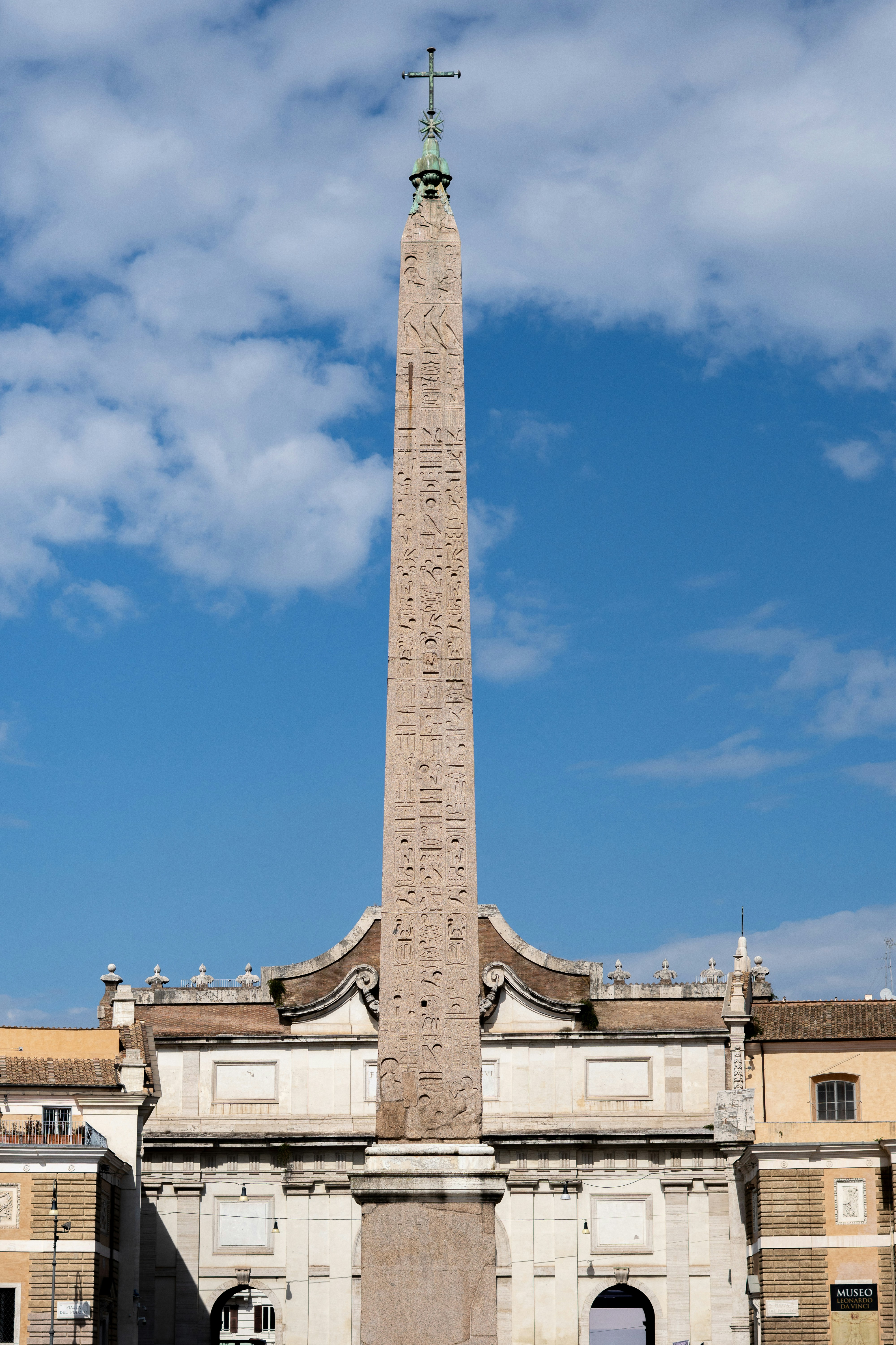 An ancient obelisk stands tall against a blue sky.