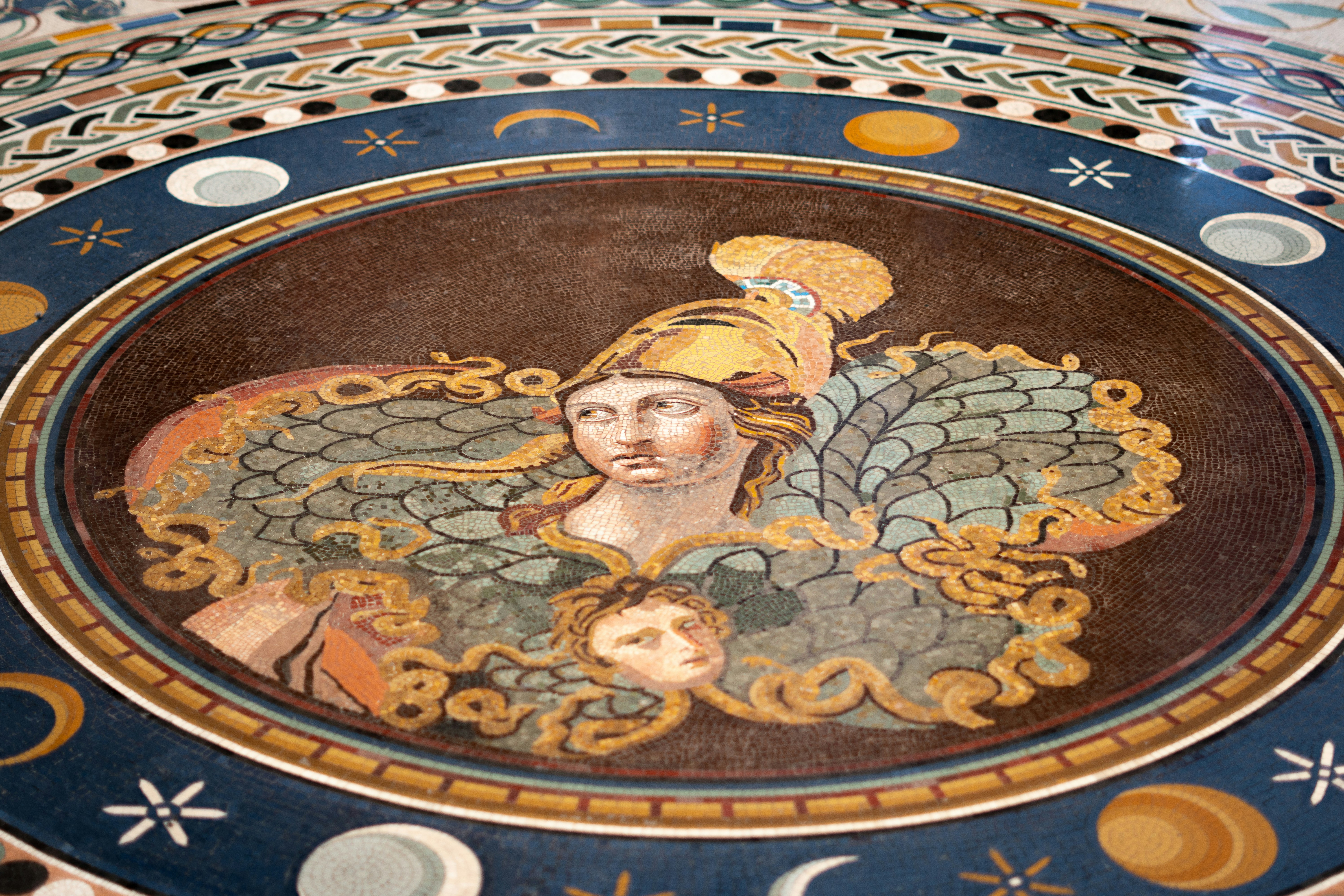 Ancient mosaic of a helmeted woman with mythological figures.