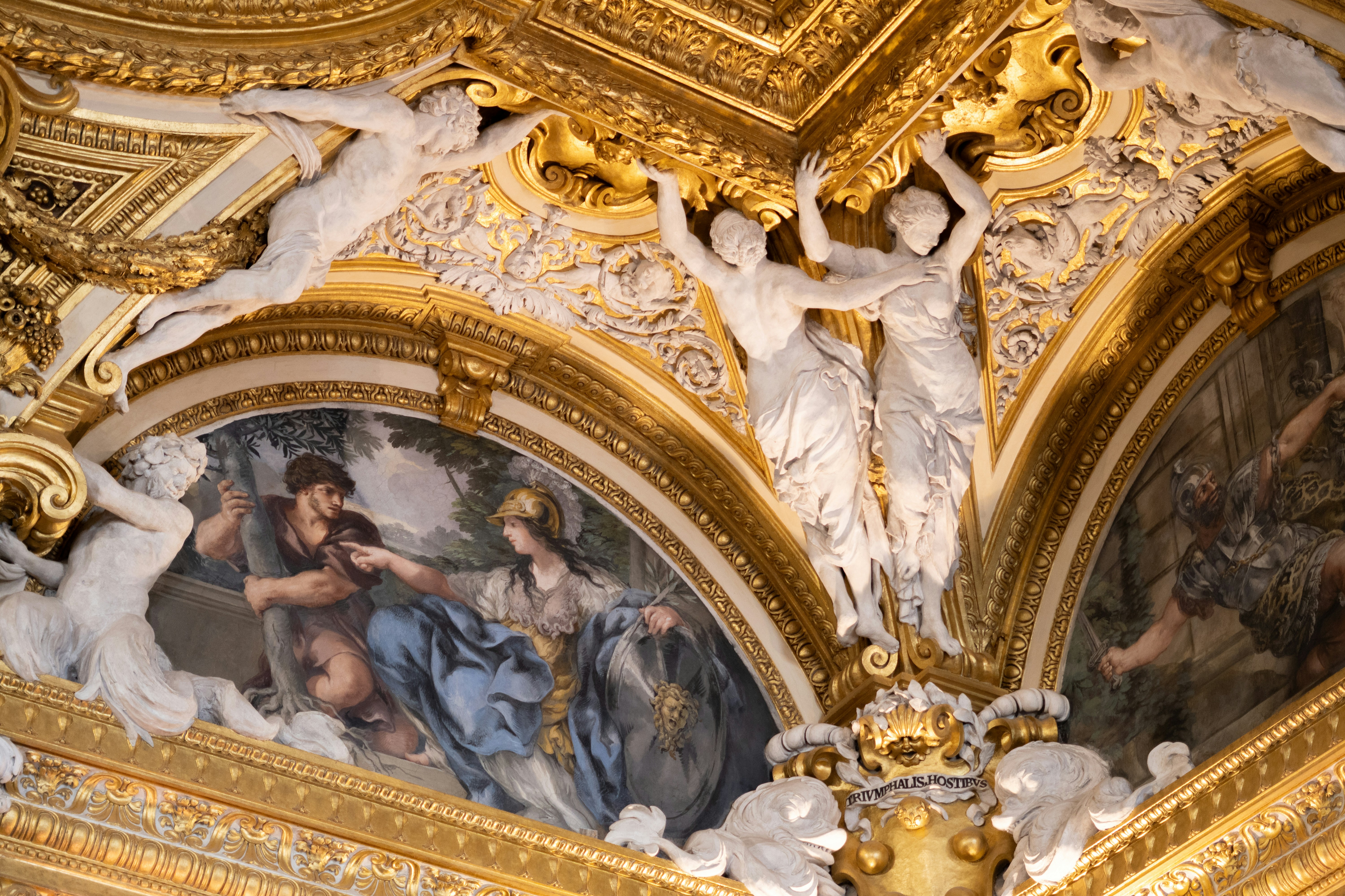 Ornate gilded ceiling with painted murals and sculptures.
