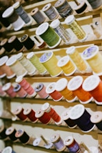 Various spools of thread on a wooden rack