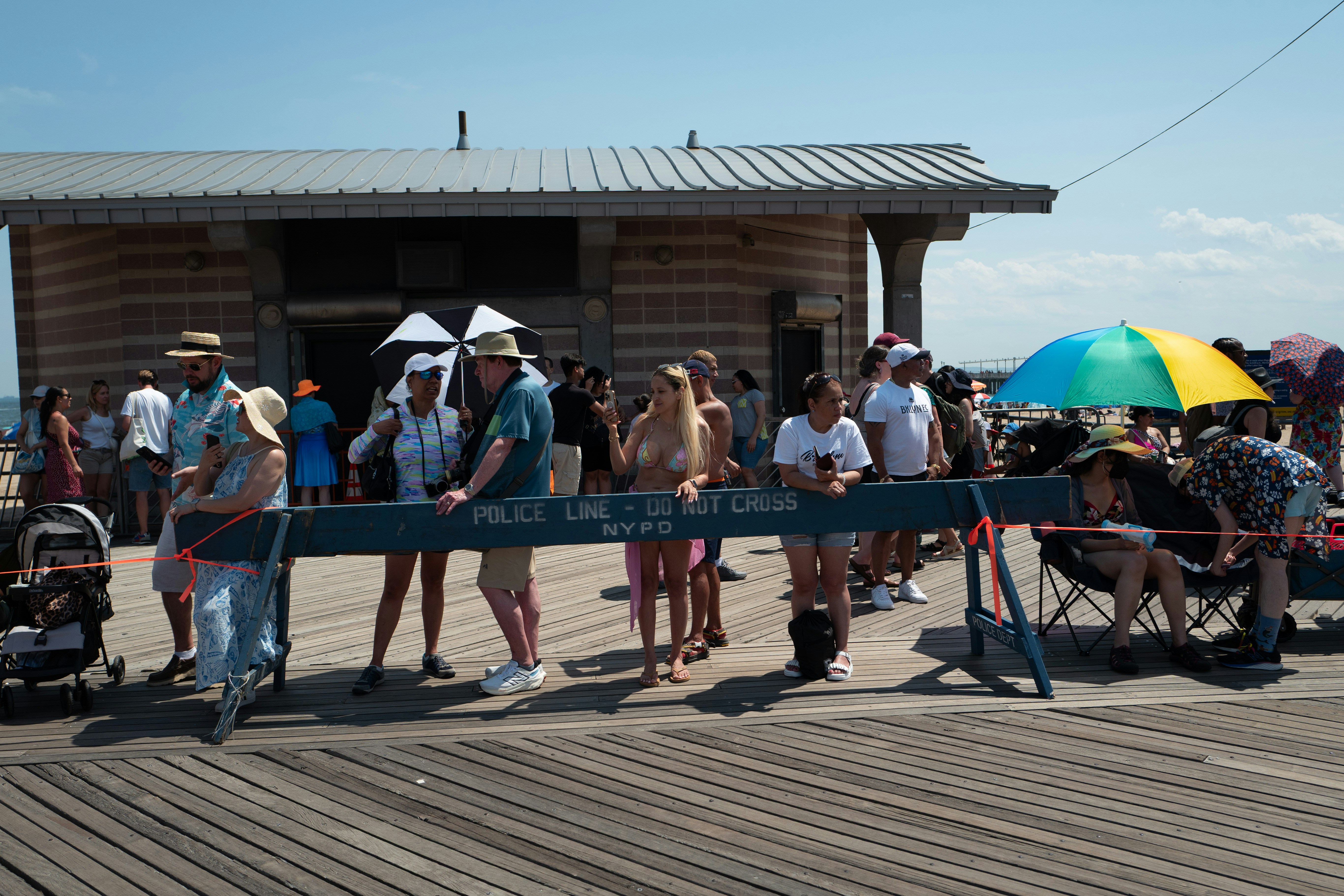 People gathered on a boardwalk near a building.