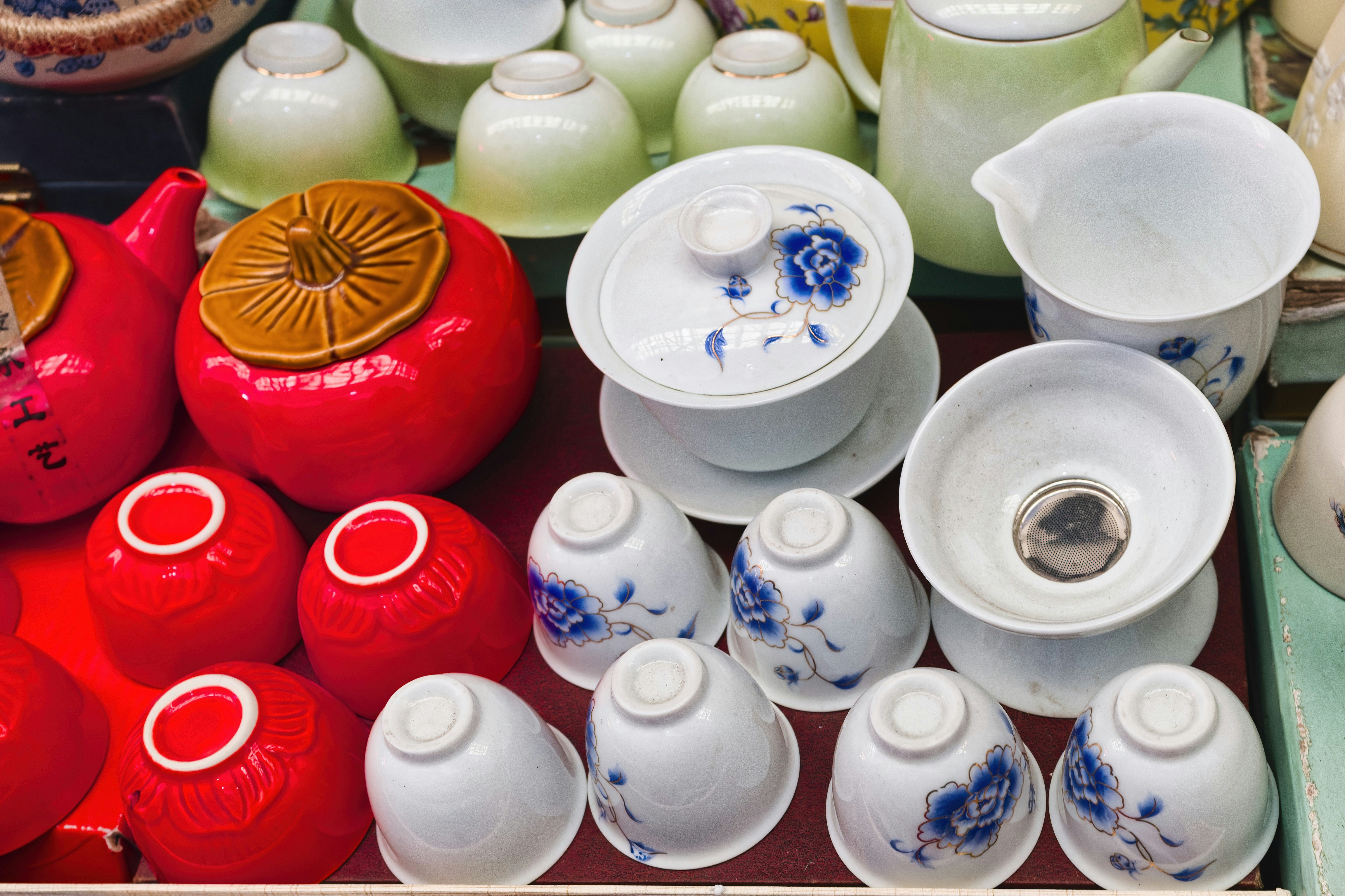 Various red and white tea cups and teapots