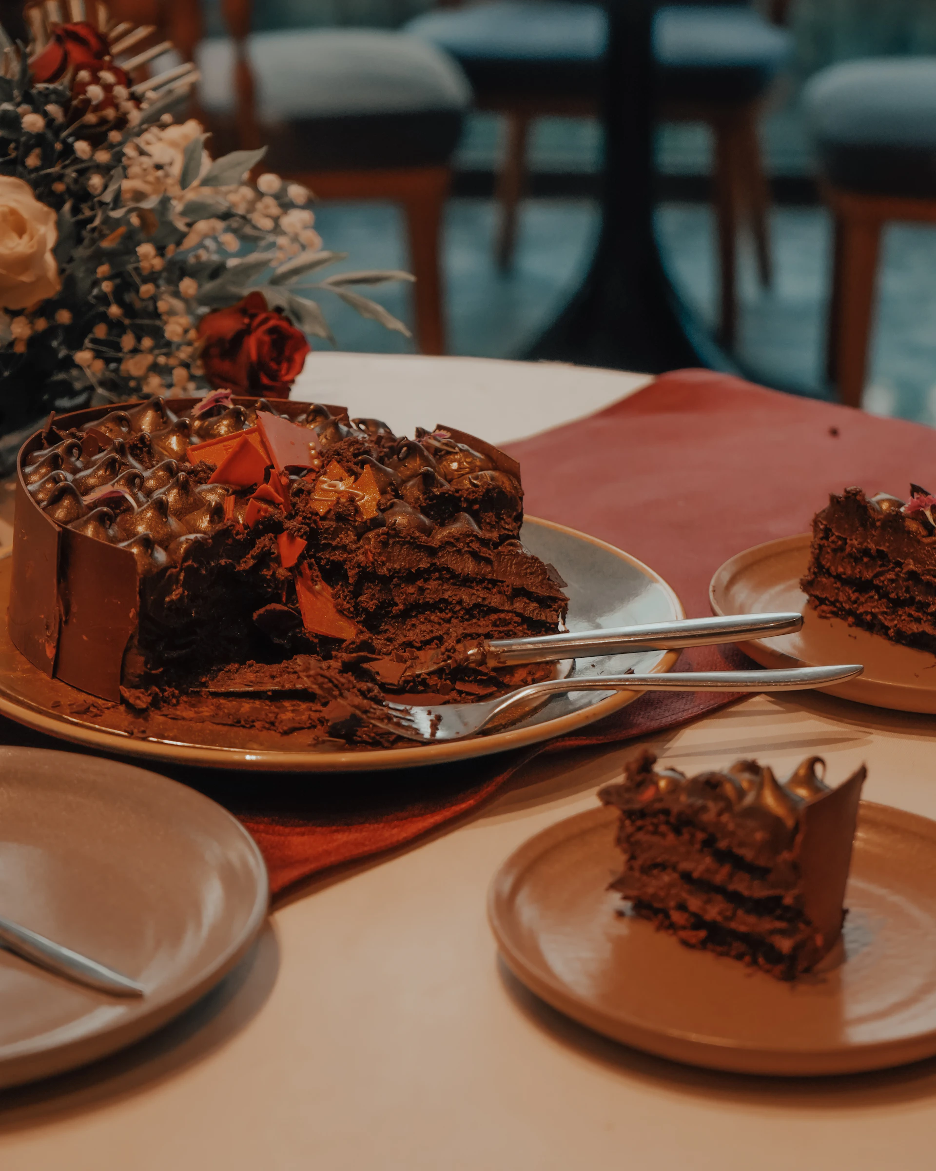 A decadent chocolate cake with slices on plates.