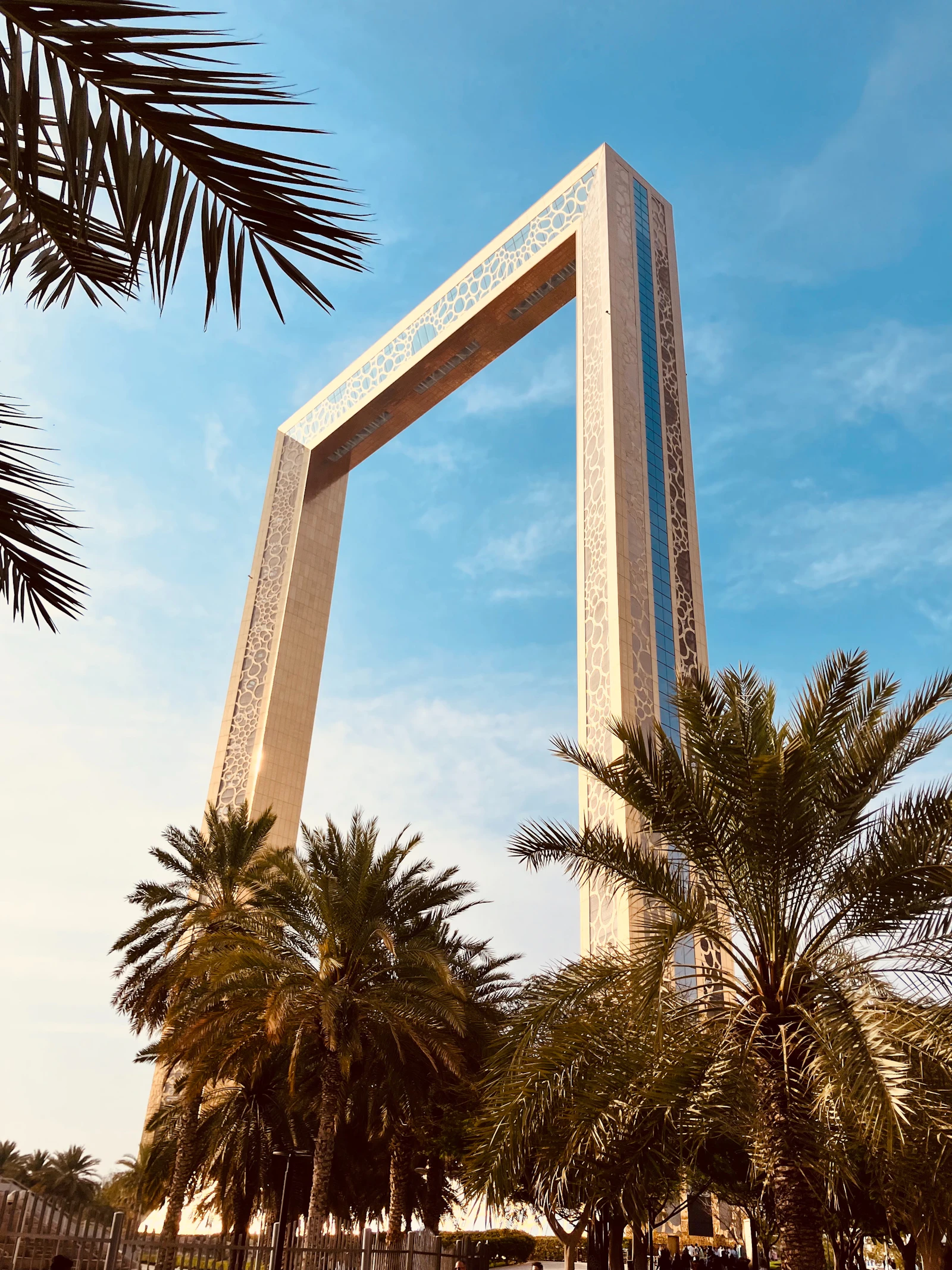 Dubai Frame seen from below between palm trees