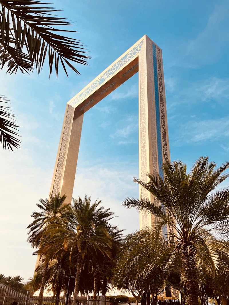 Dubai Frame seen from below between palm trees