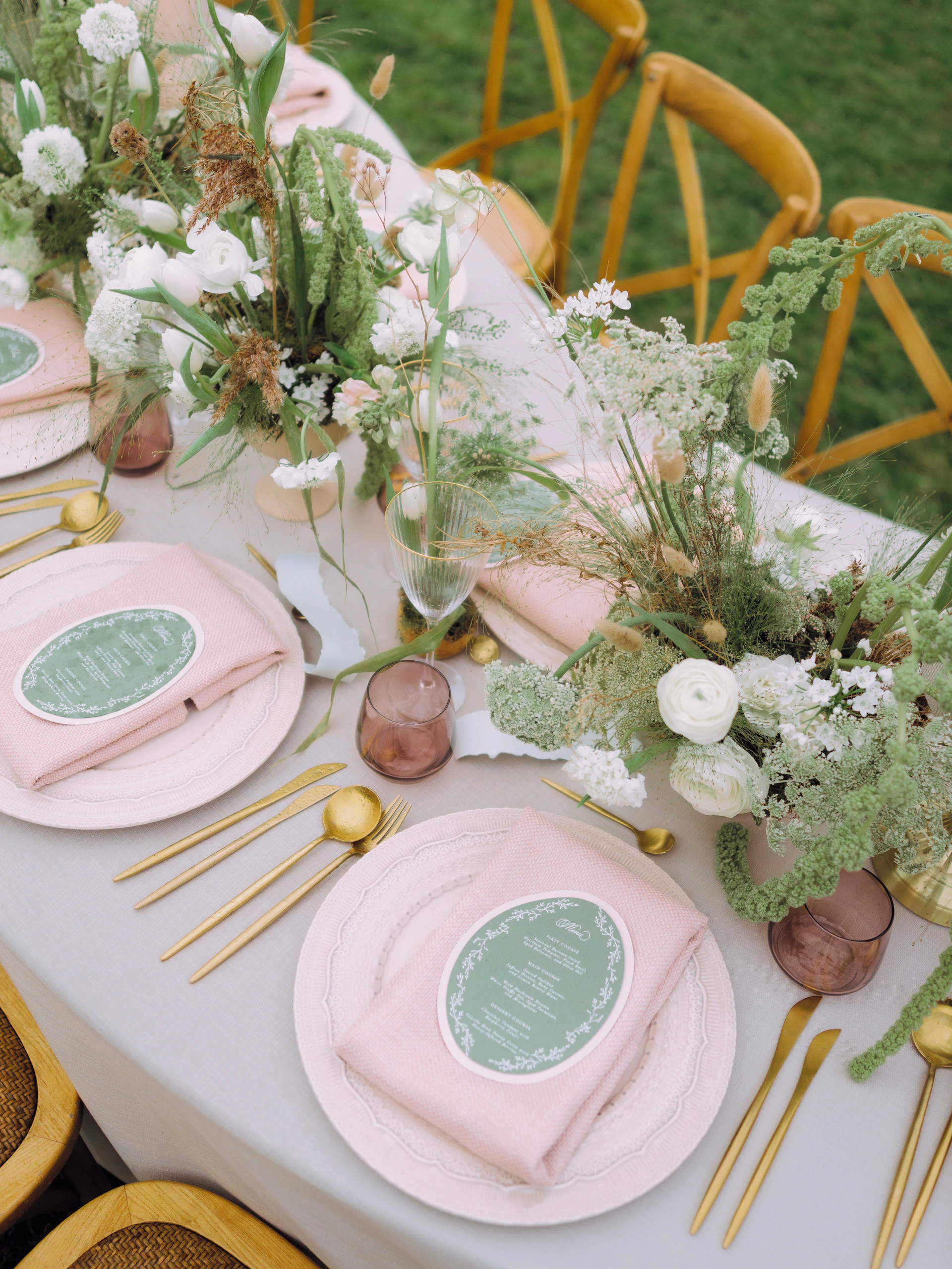 Elegant table setting with floral arrangements and gold cutlery.