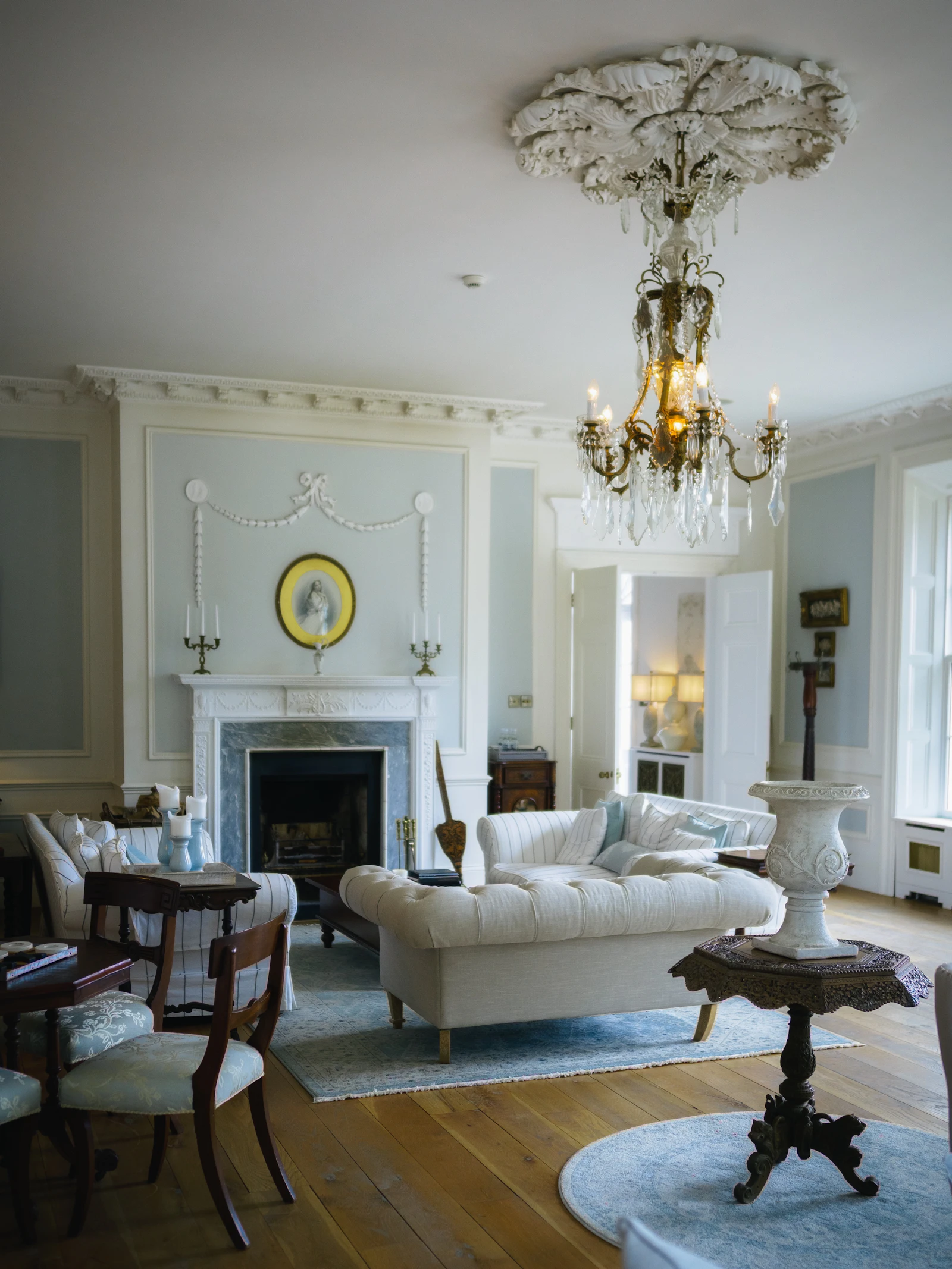 Restored drawing room with a marble fireplace, plaster mouldings and a chandelier