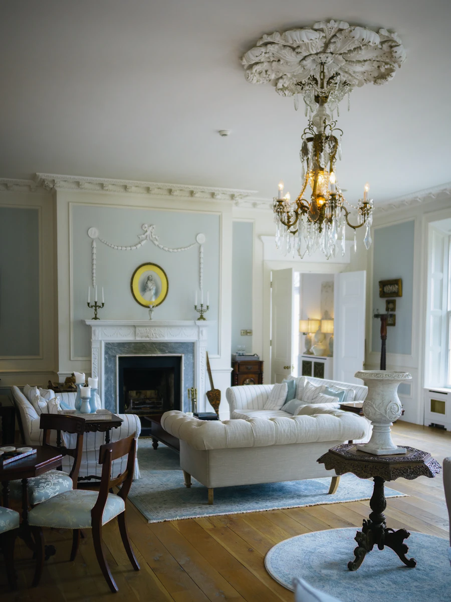 A refined drawing room with a crystal chandelier, fireplace and antique furniture
