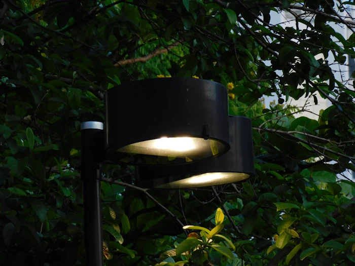 Two outdoor lamps lit at dusk