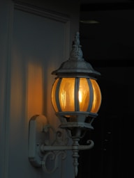 Декоративен бял фенер, който излъчва мек, топъл блясък по здрач в пловдивската вечерна светлина.