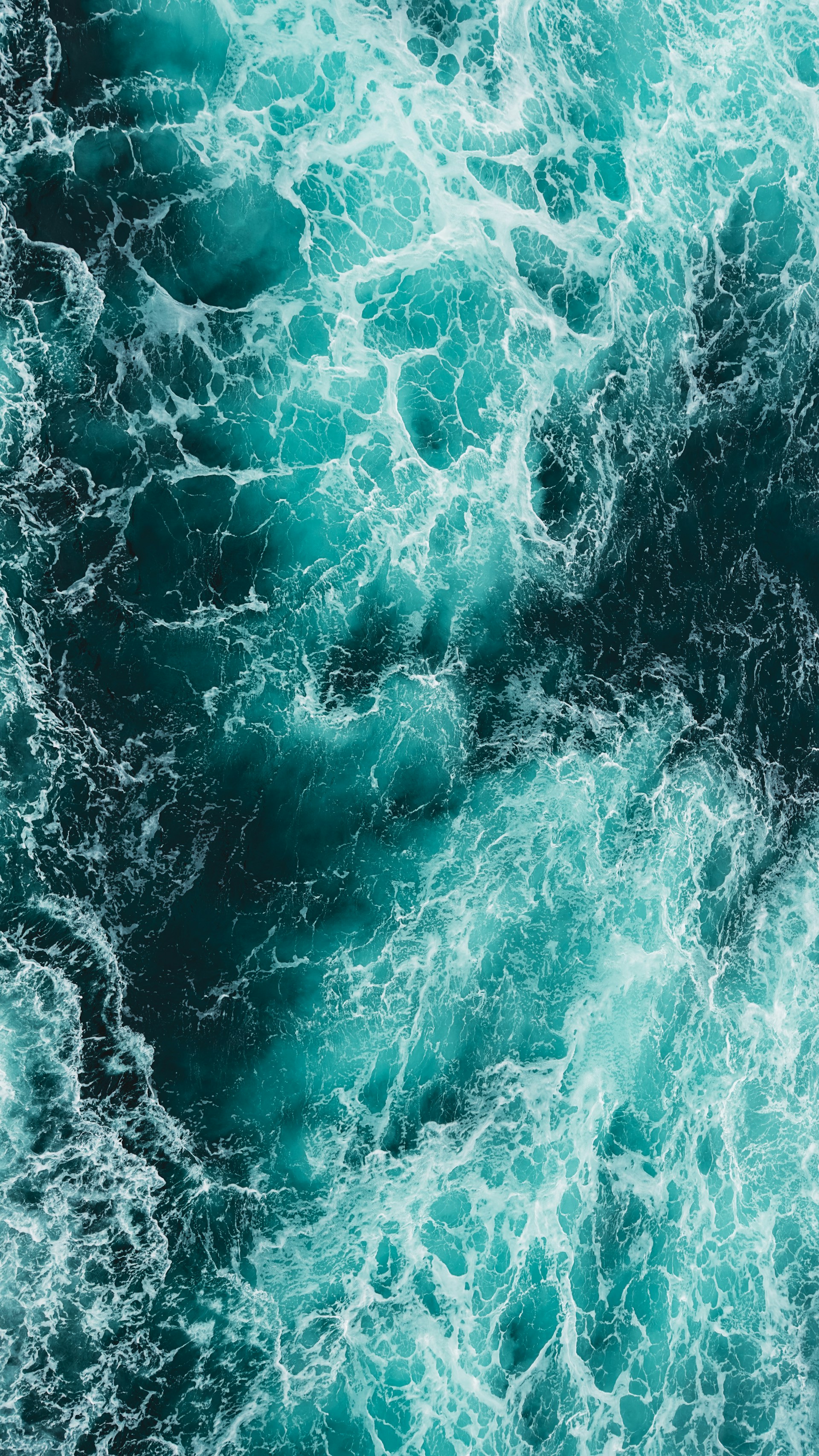 Turquoise ocean water with white foam patterns