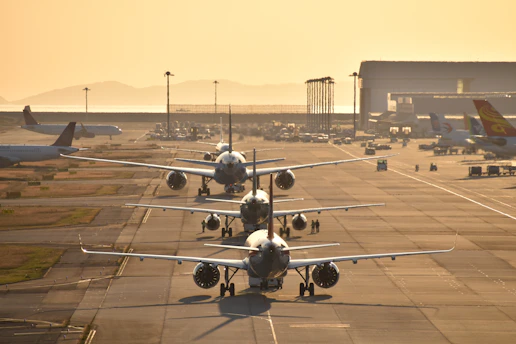 Airplanes lined up on a runway at sunset
