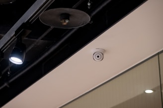 Security camera mounted on a white ceiling.