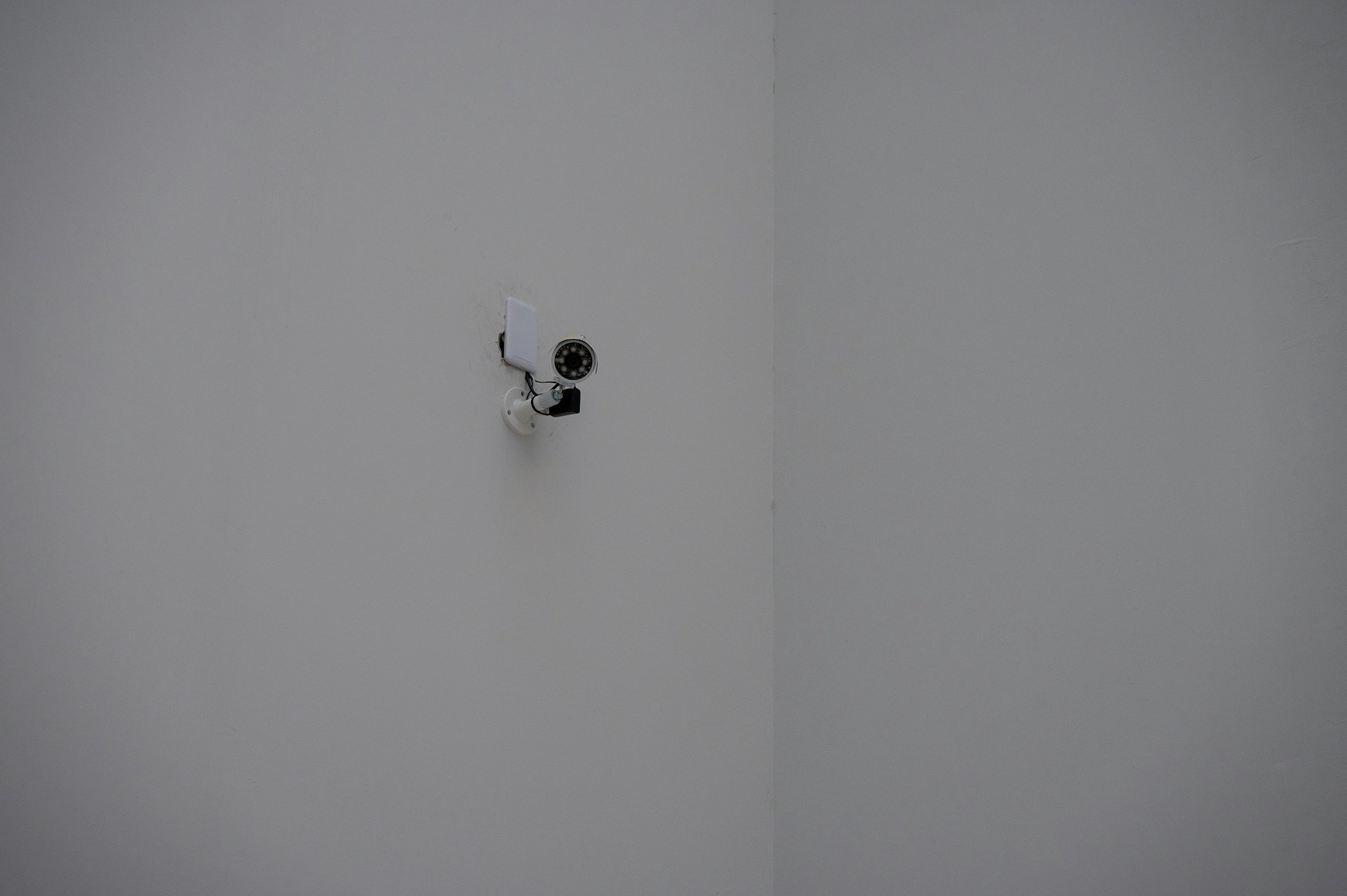 A security camera mounted in a white corner.