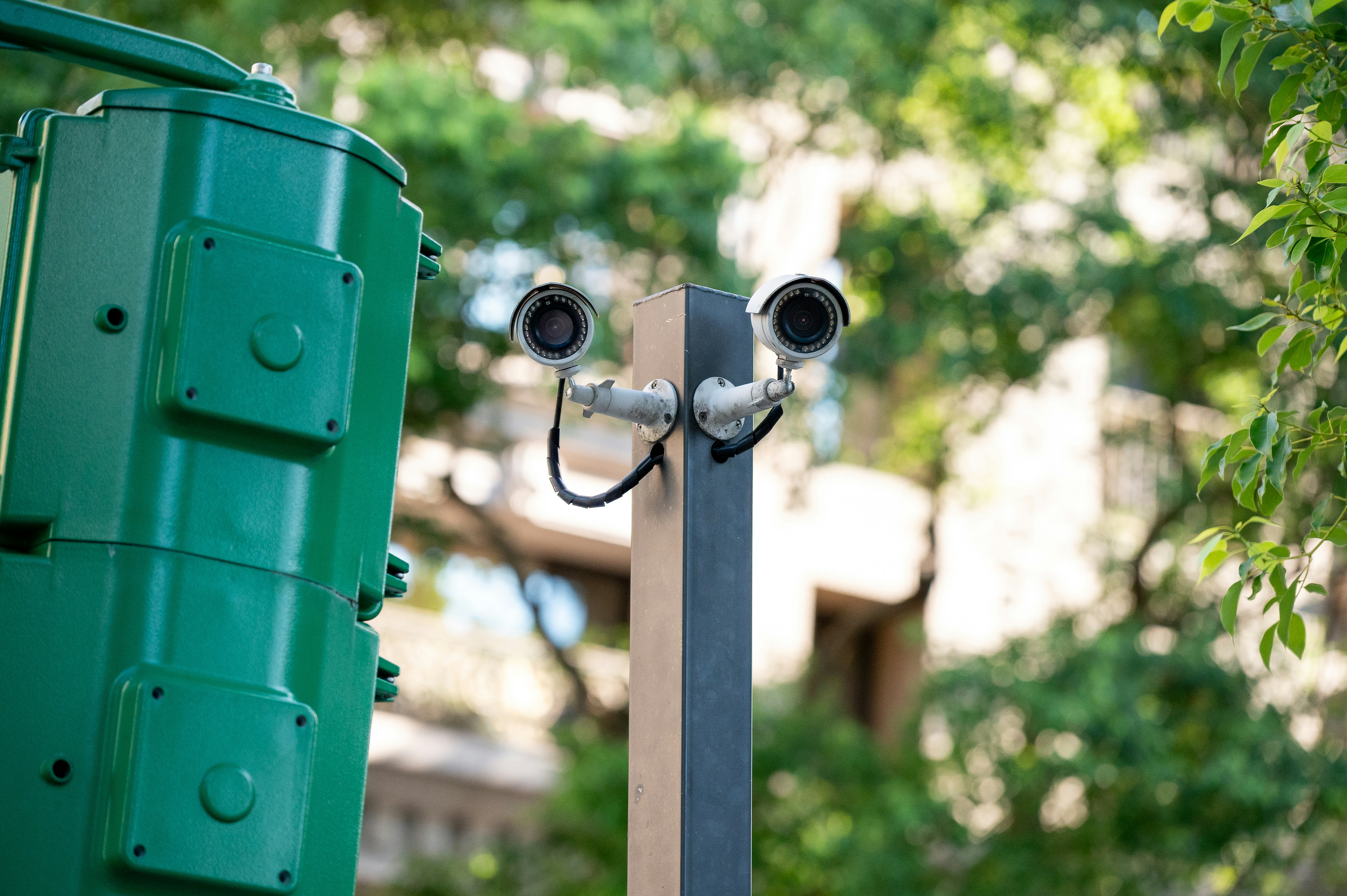 Two security cameras mounted on a pole.