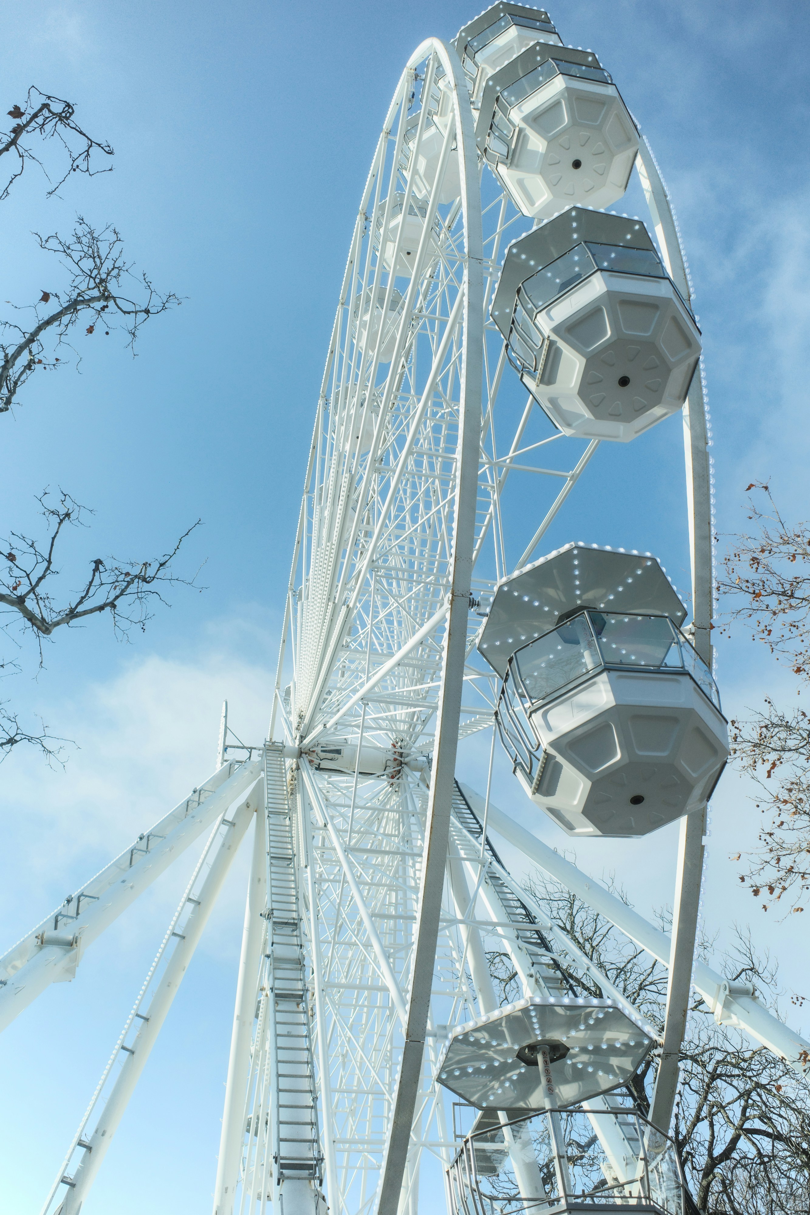 A tall white ferris wheel against a blue sky.