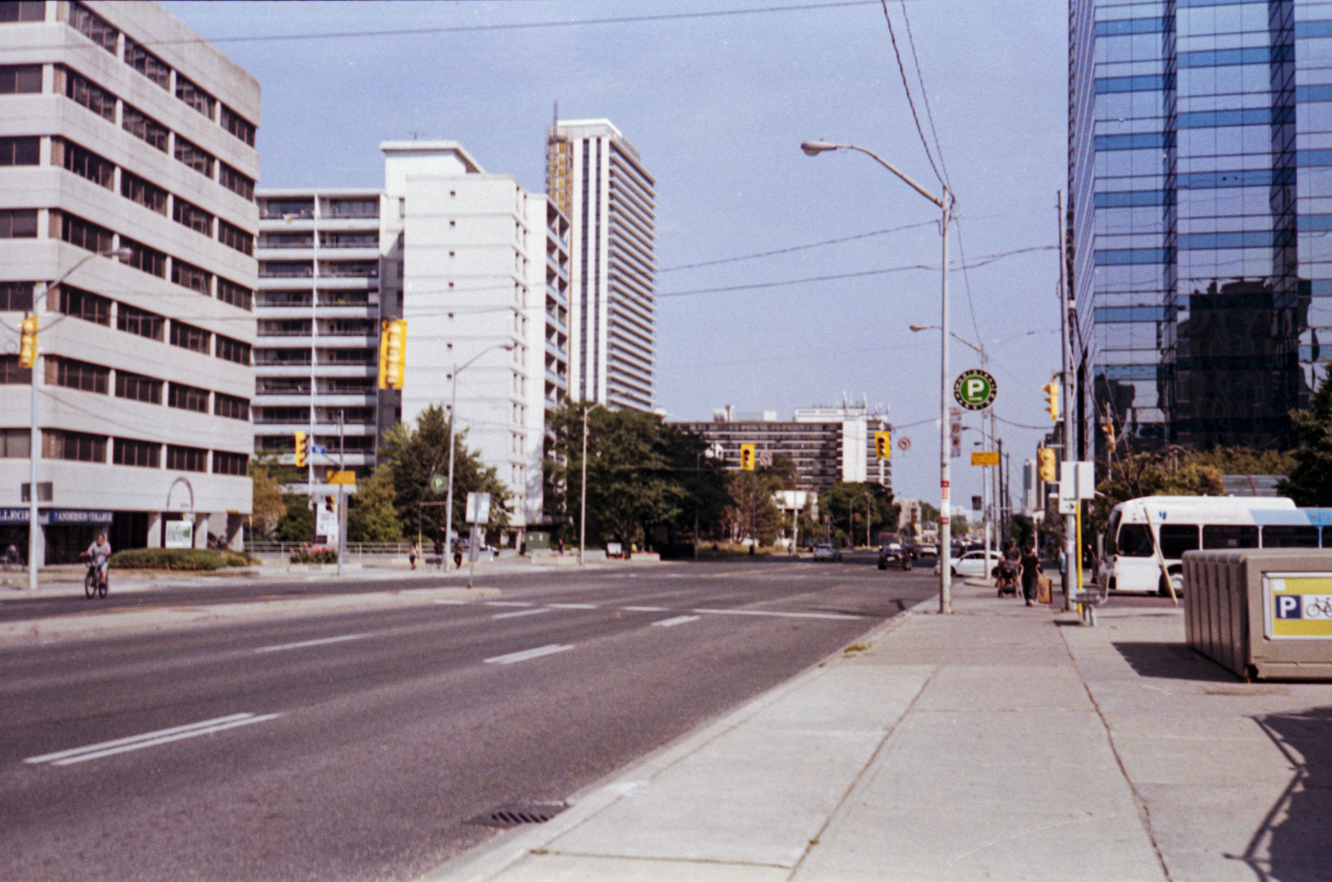 City street with buildings and a bus on the right.