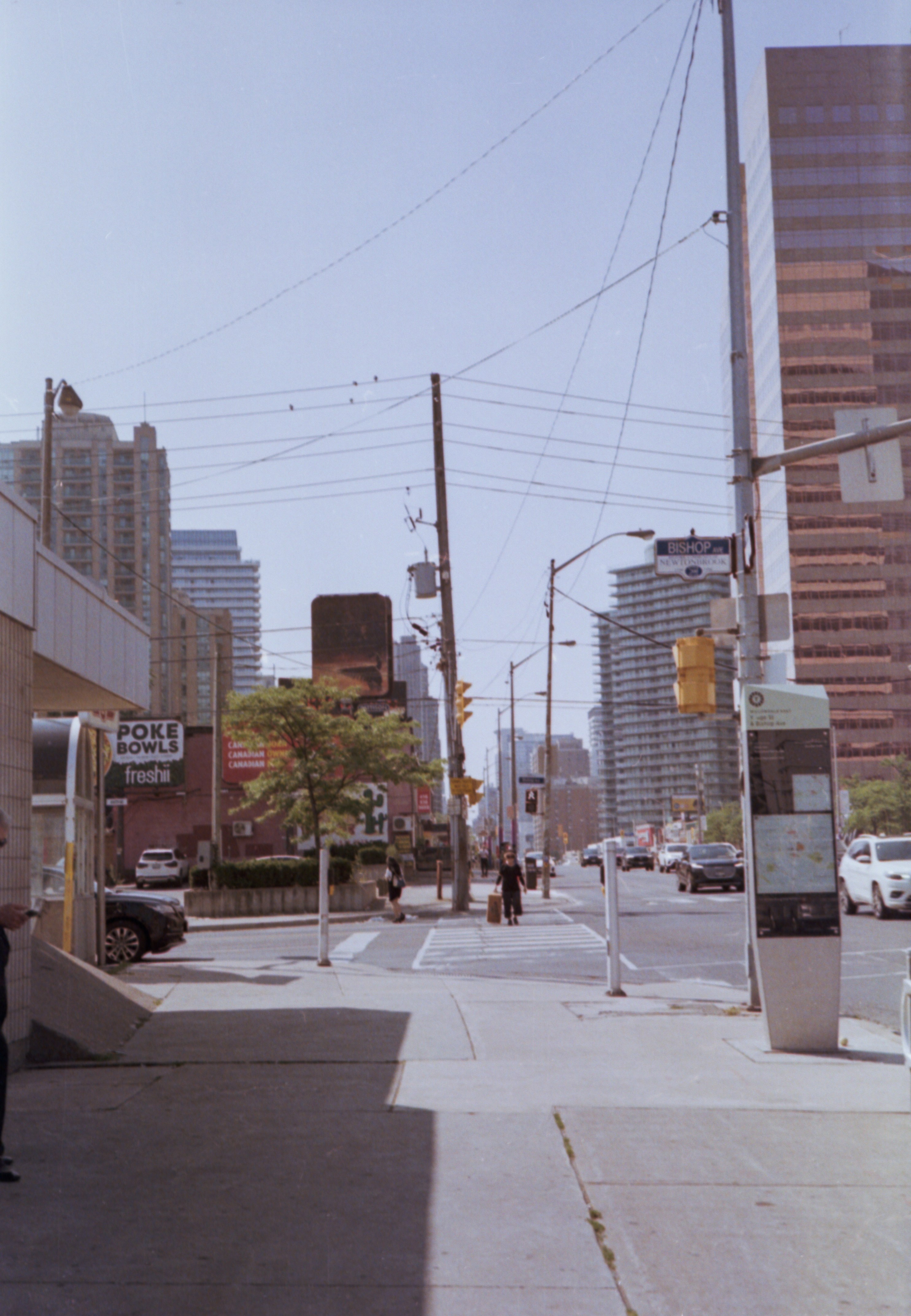 City street with buildings, cars, and power lines.