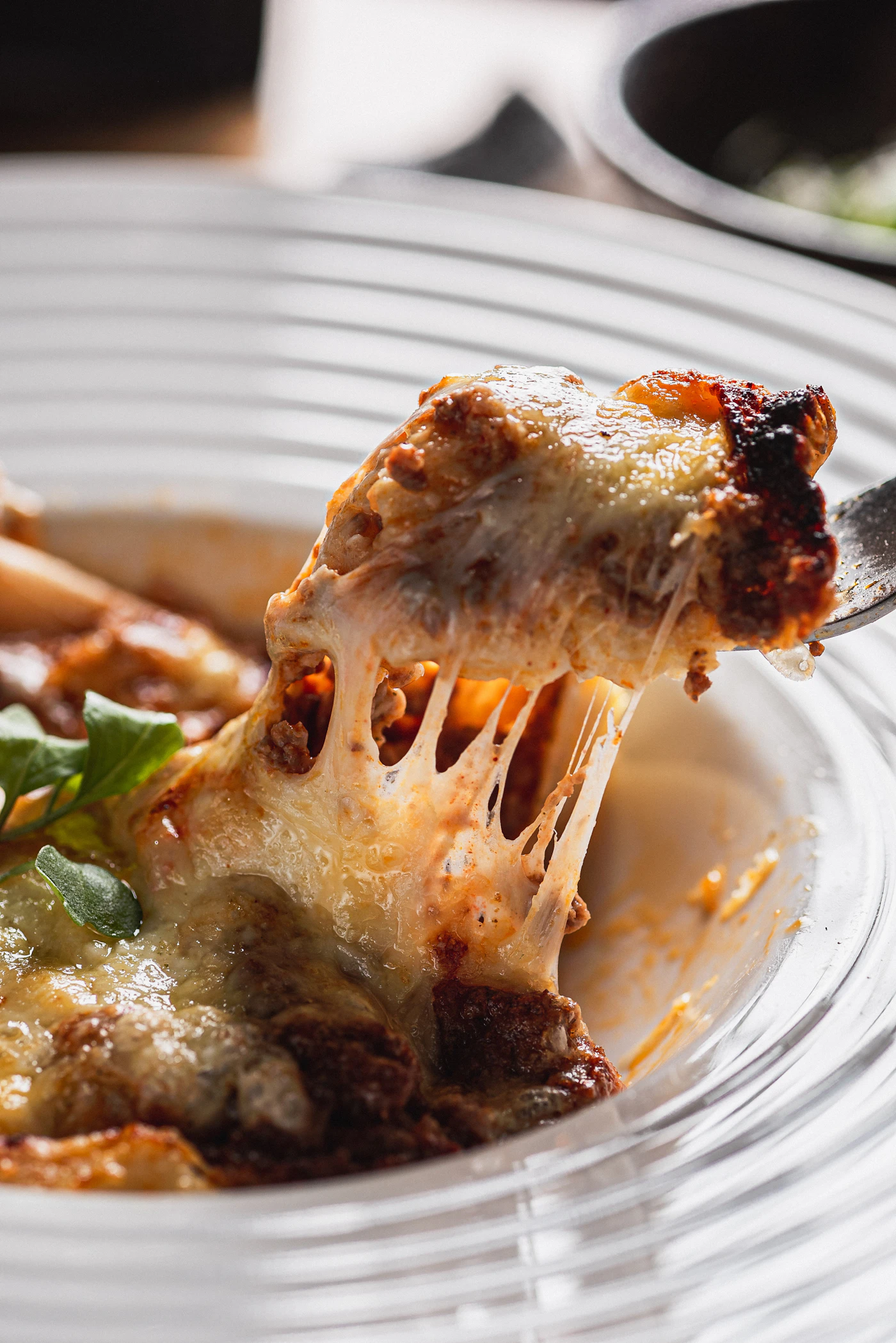 Une part de lasagnes fondantes soulevée à la fourchette