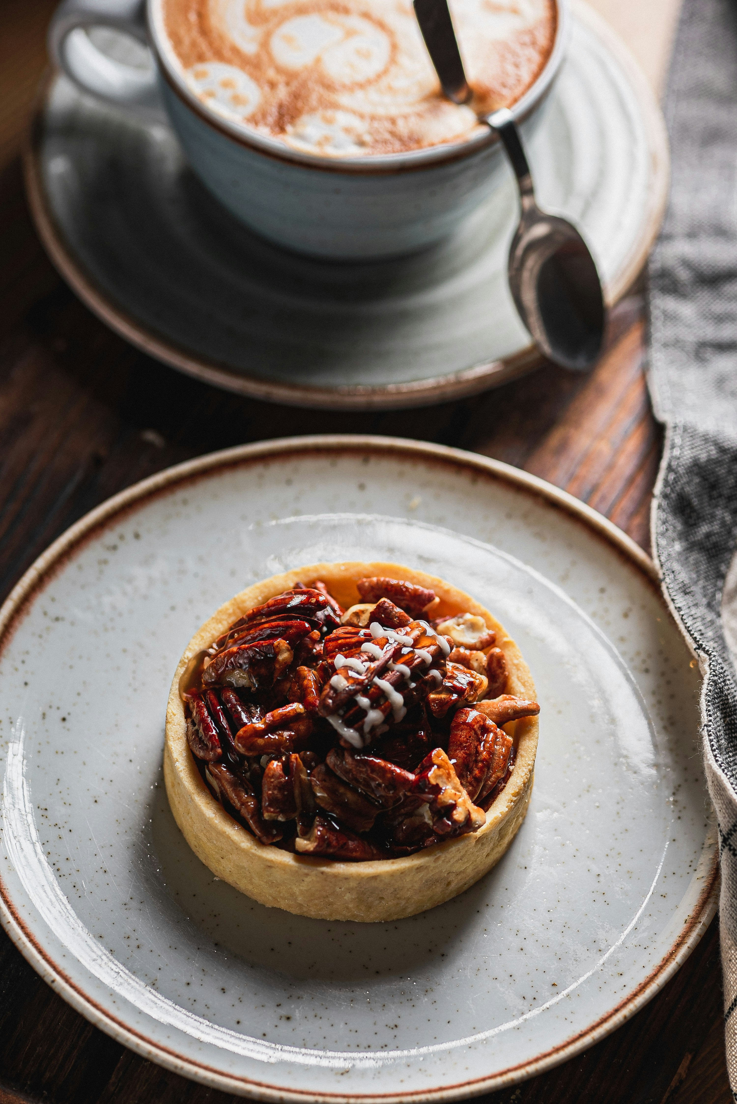 Pecan tart with a latte on a wooden table