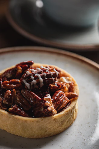 A delicious pecan tart with glaze on a plate.
