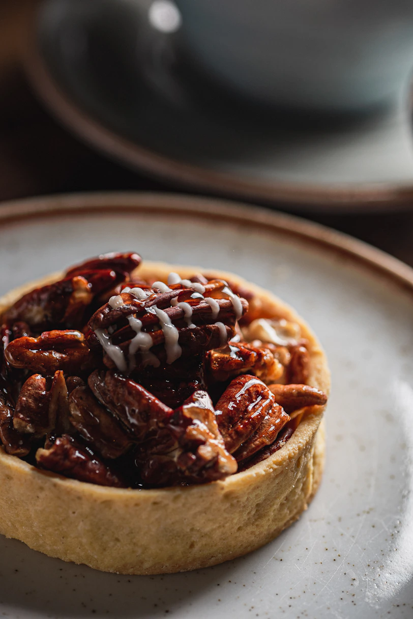 A delicious pecan tart with glaze on a plate.